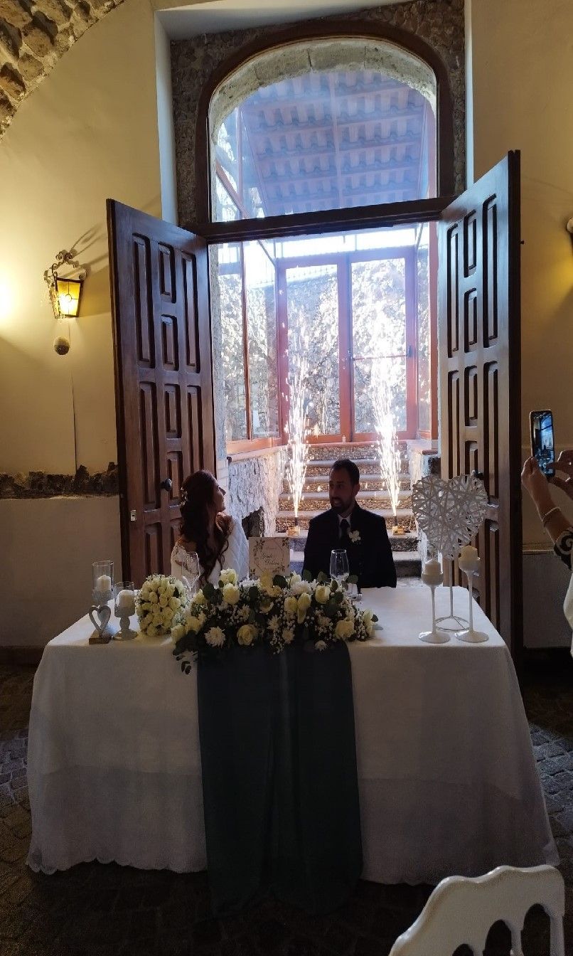 Gli sposi sono seduti a un tavolo davanti a una finestra.