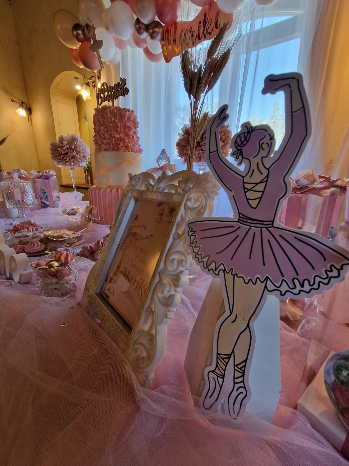 ballerina seduta su un tavolo con palloncini e fiori