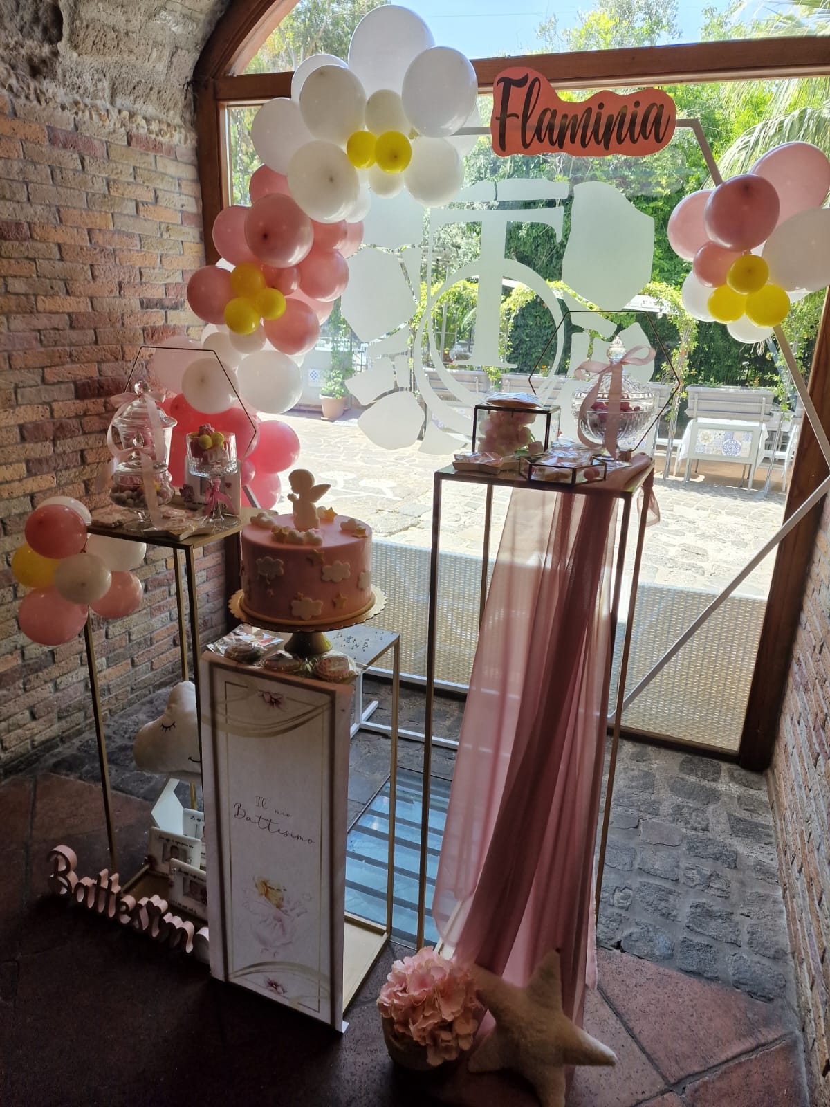 torta rosa a più piani allestita per un battesimo