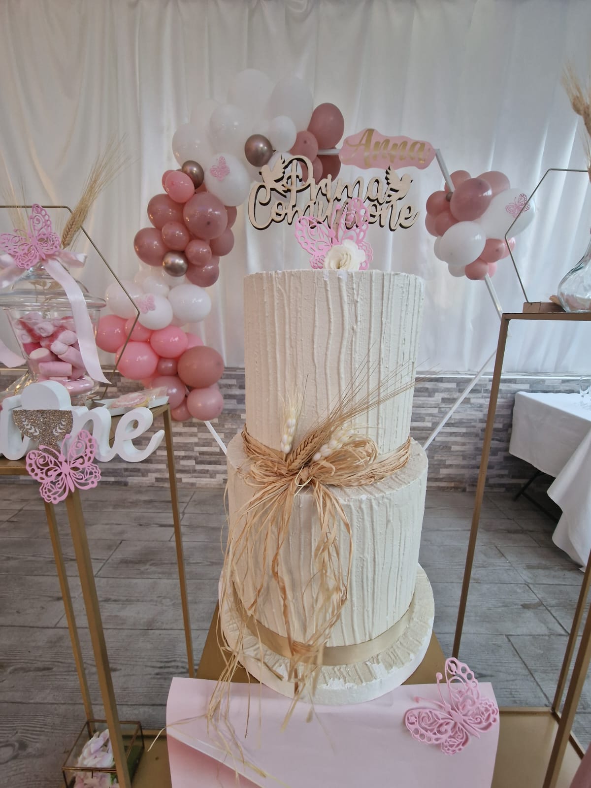 tavolo con una torta bianca con dei palloncini sopra