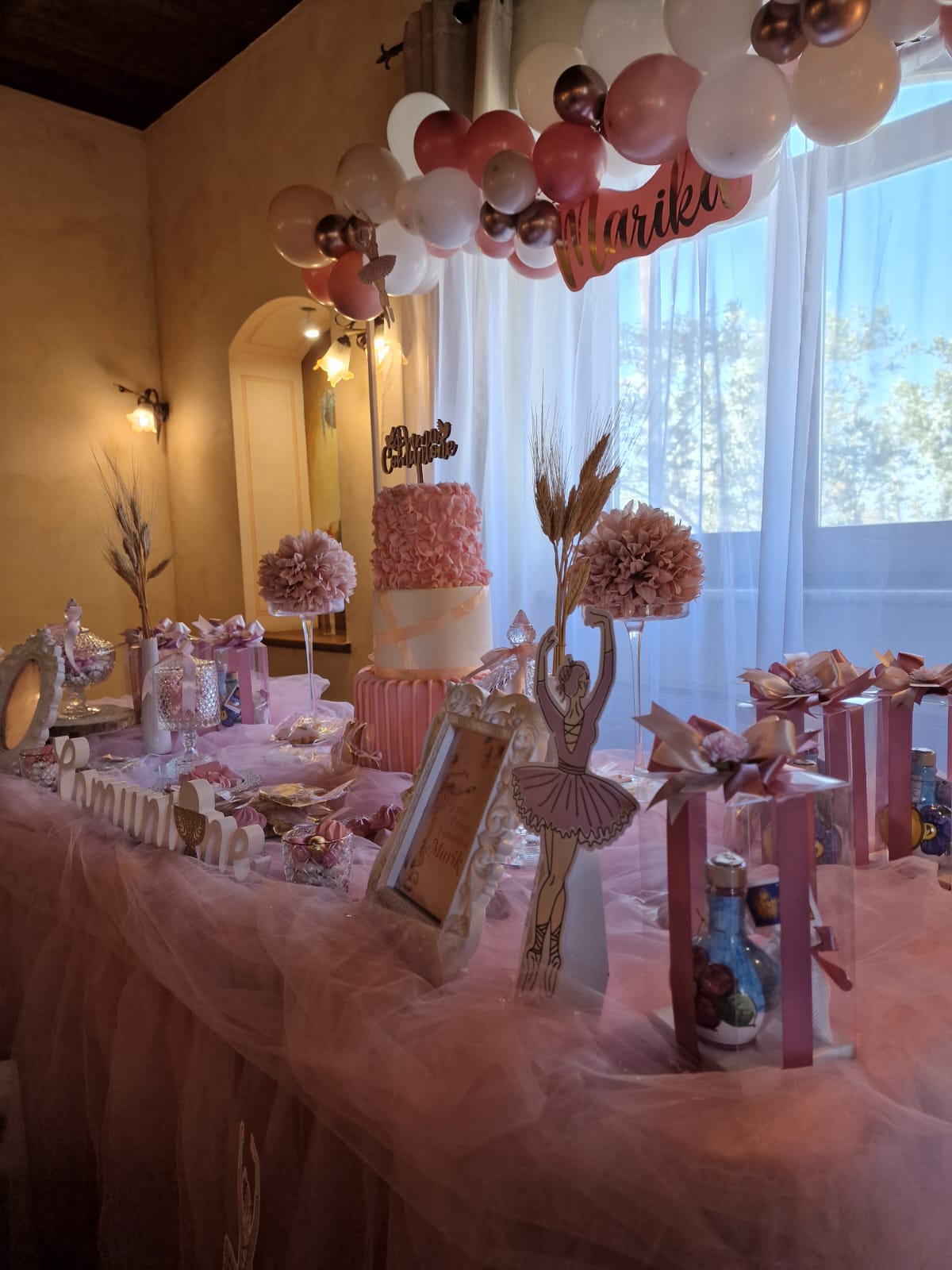 tavolo decorato per una festa di compleanno con palloncini e una torta