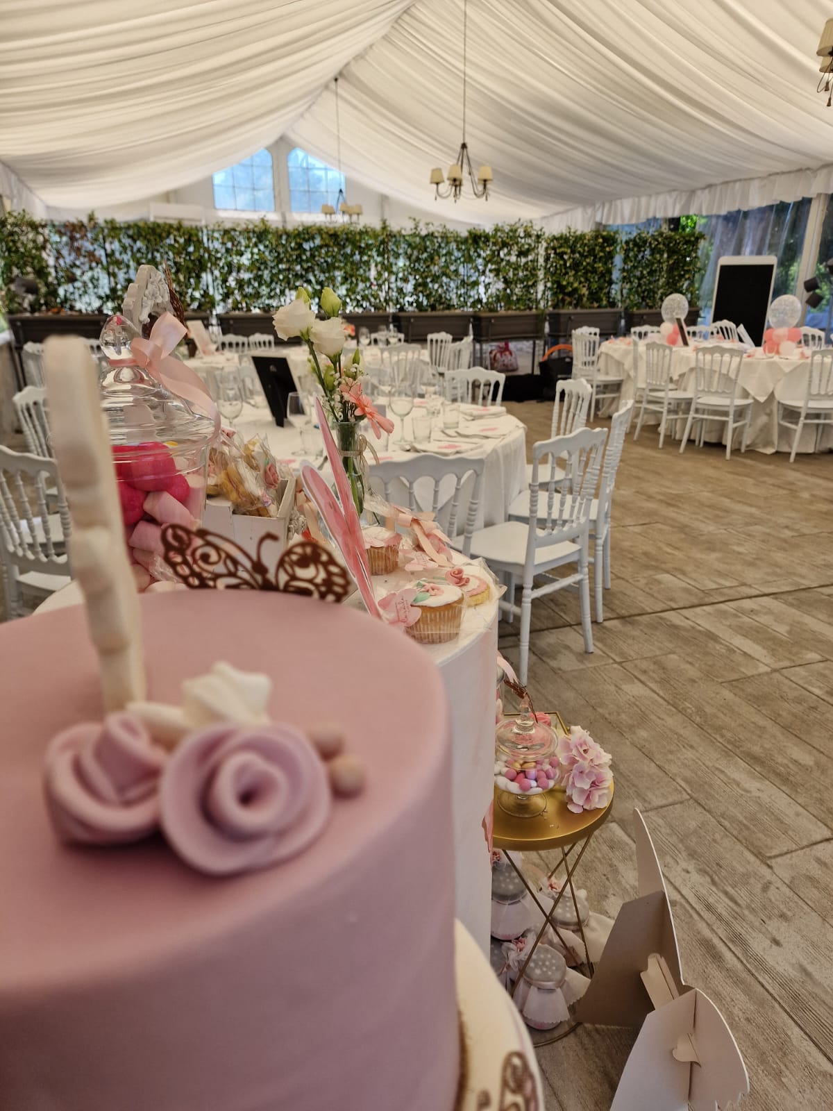 torta rosa è appoggiata su un tavolo in una stanza con tavoli e sedie