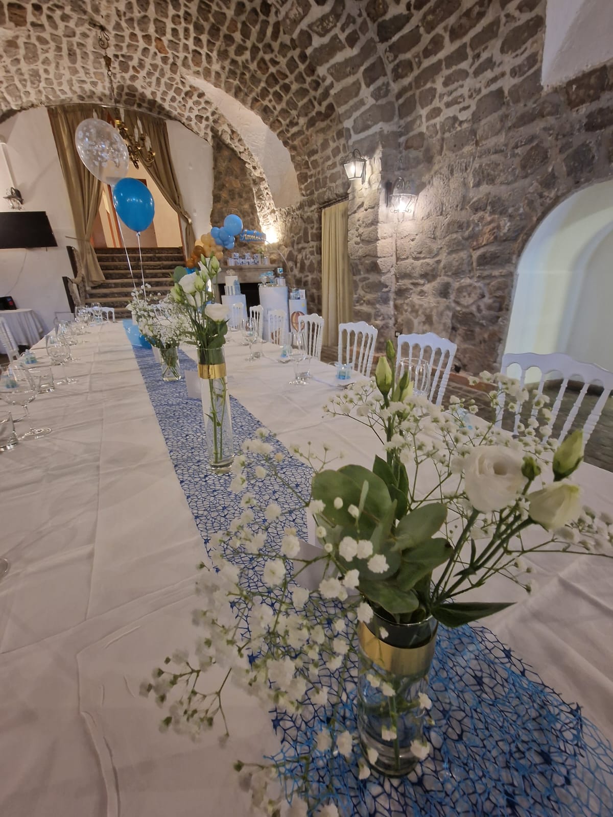 Un lungo tavolo con fiori e palloncini sopra.