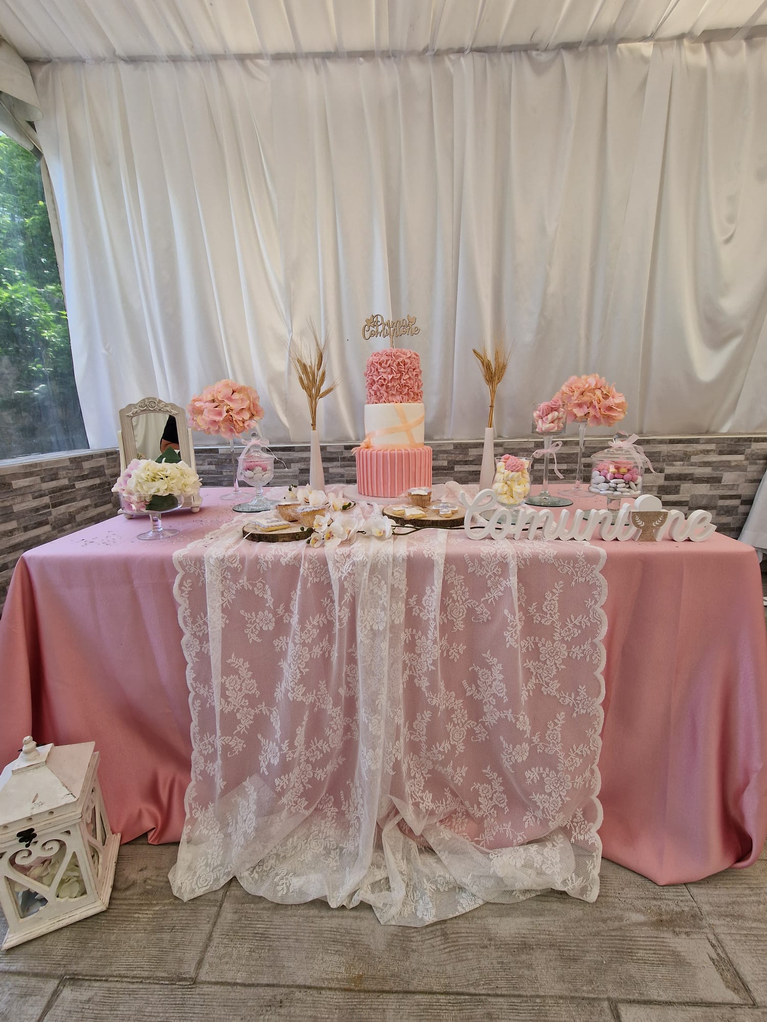 tavolo con una tovaglia rosa e un centrotavola di pizzo bianco