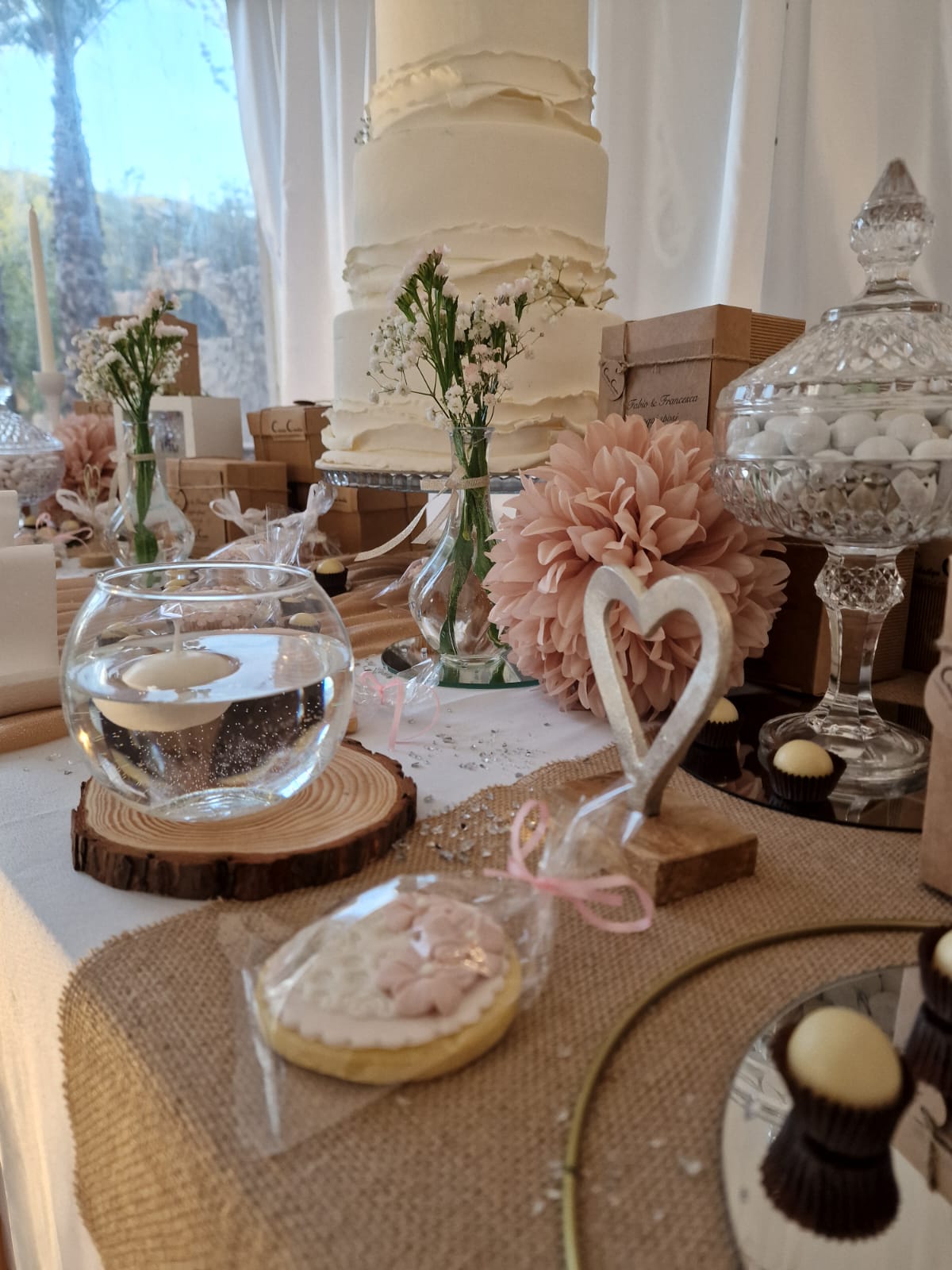 tavolo decorato per un matrimonio con una torta sullo sfondo
