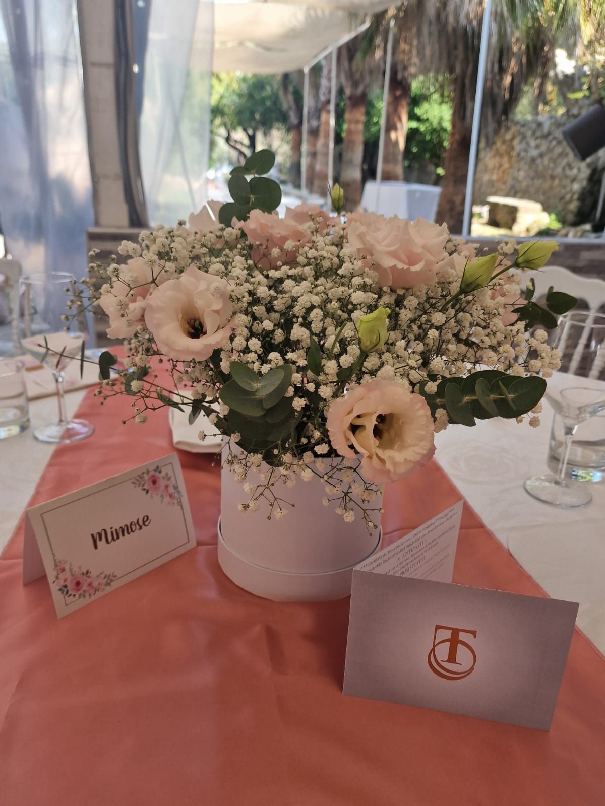 tavolo con un vaso di fiori e un segnaposto sopra