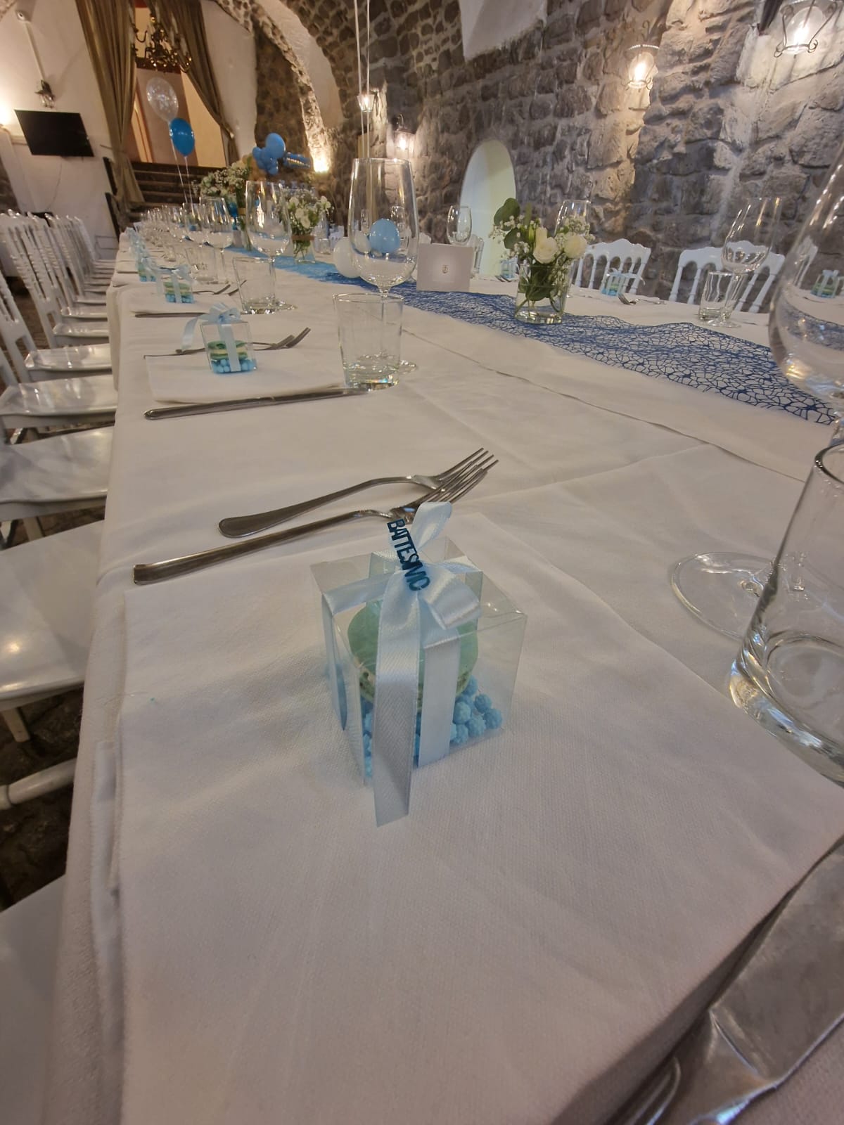 lungo tavolo con una tovaglia bianca e posate d'argento