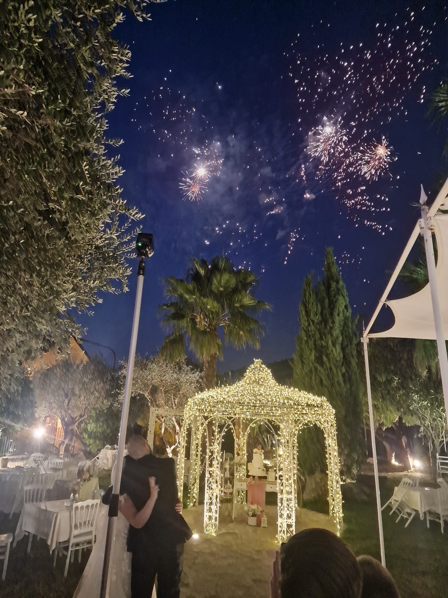 coppia di sposi davanti a un gazebo che guarda i fuochi d'artificio