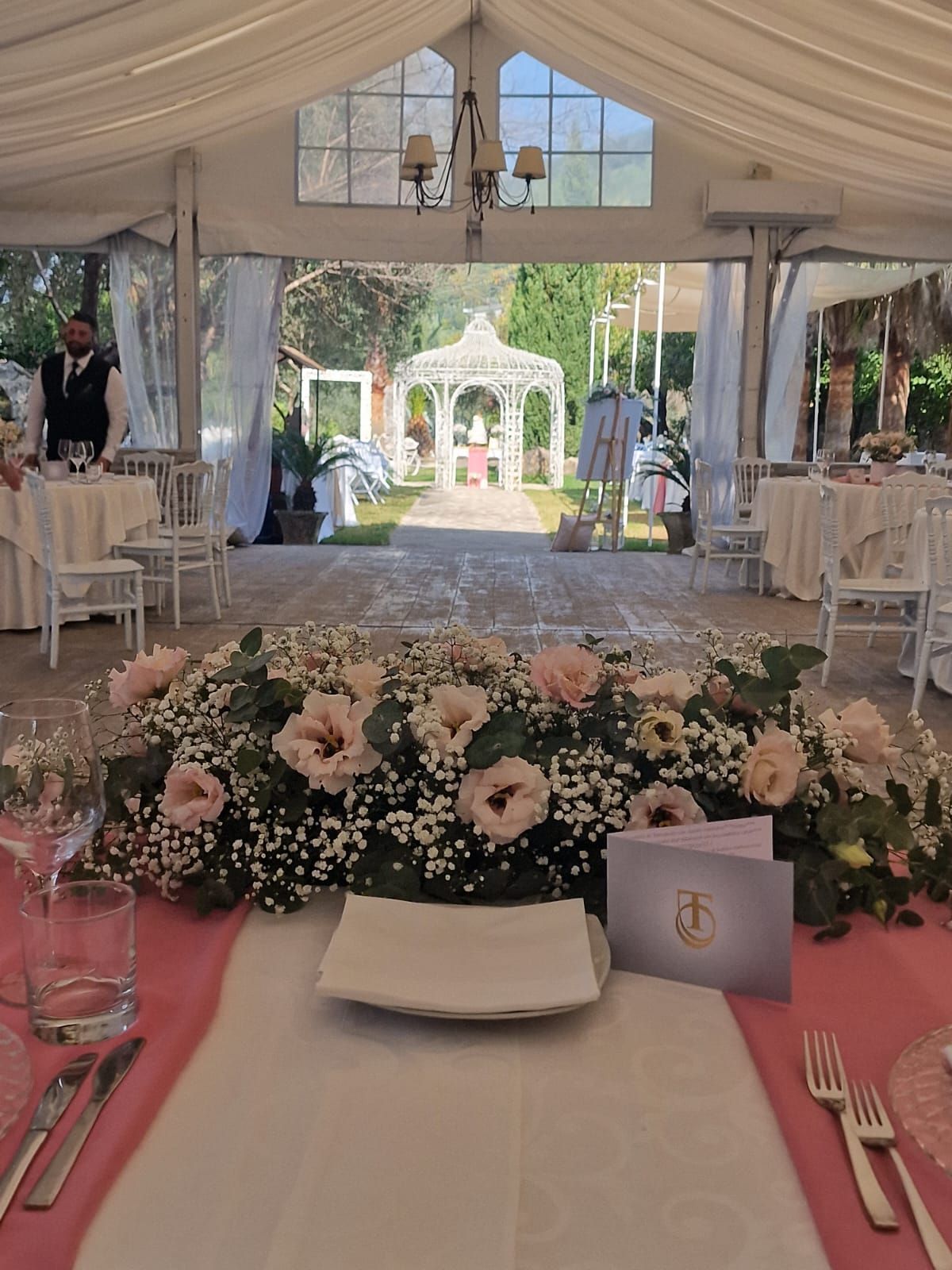 tavolo apparecchiato per un ricevimento di nozze con fiori sopra
