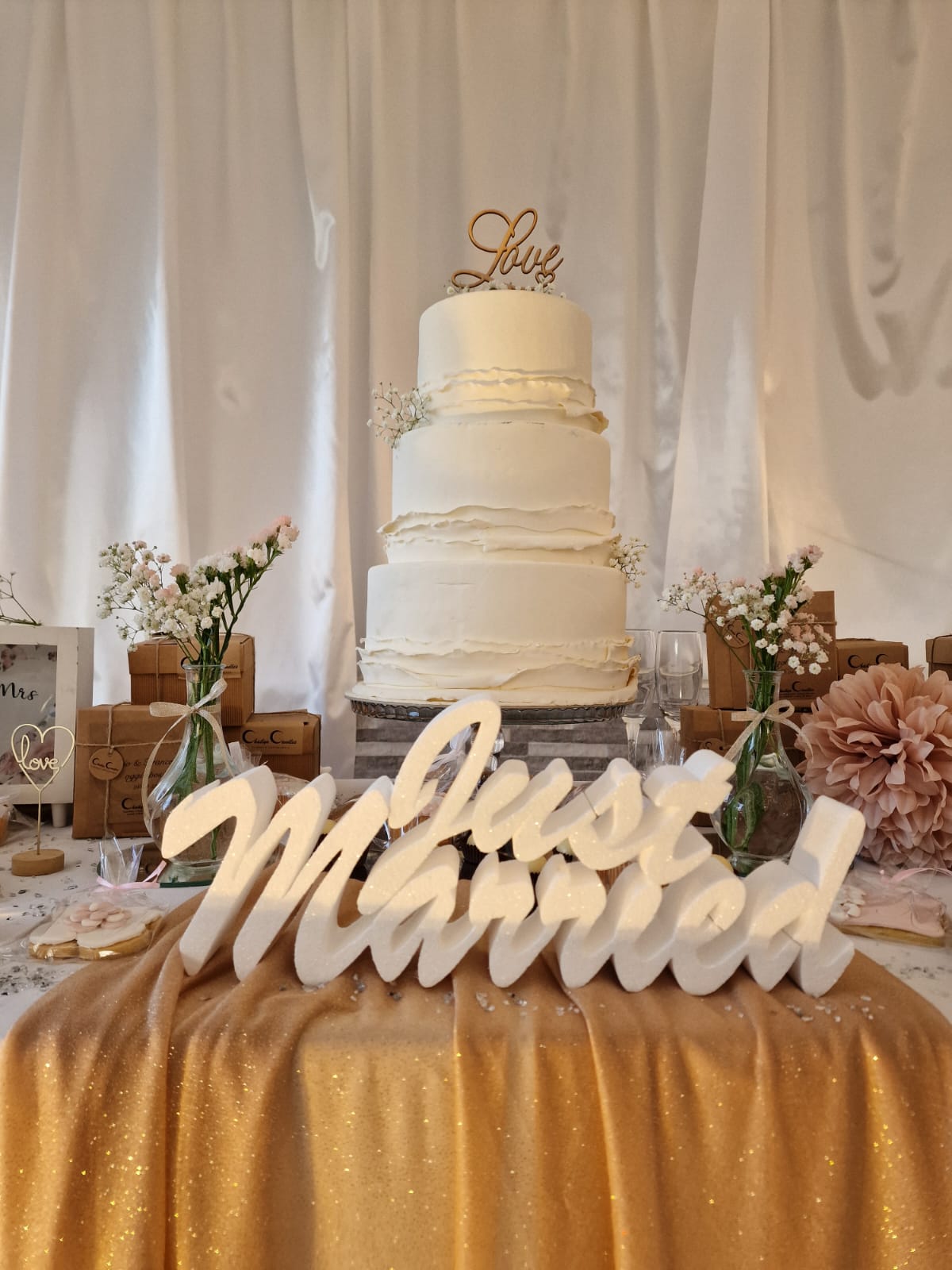 torta nuziale è appoggiata su un tavolo accanto a un cartello che dice ``sposati''.