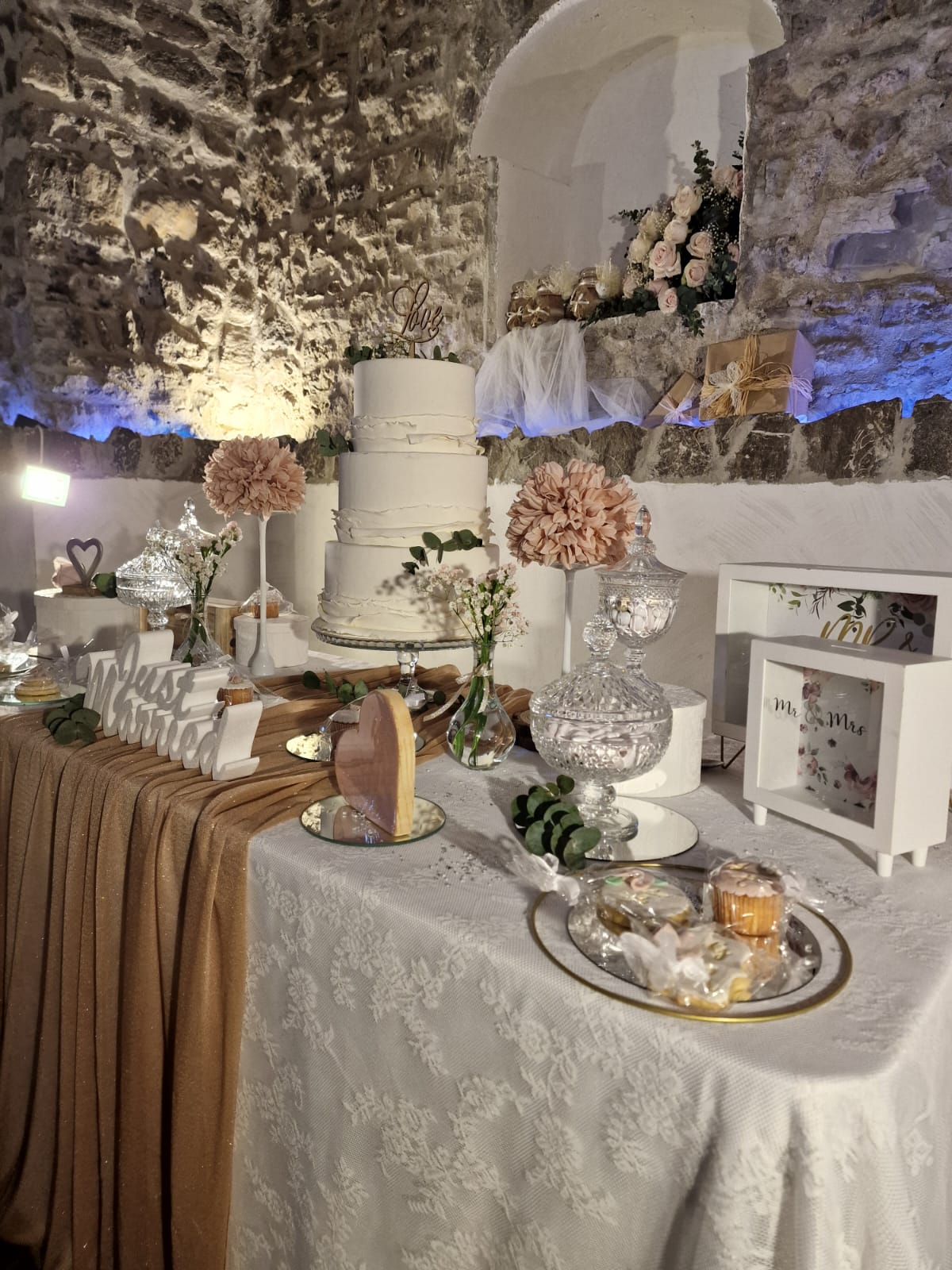 tavolo con una torta, dei dolci e dei fiori sopra