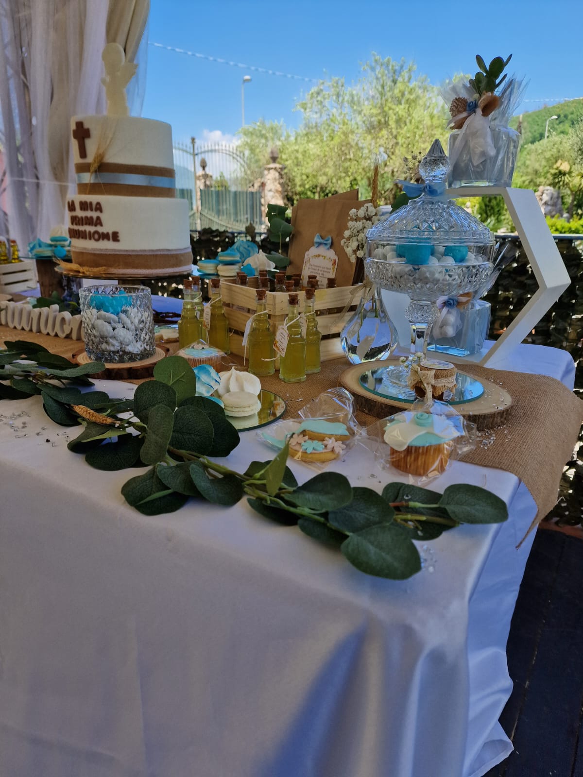 tavolo con sopra una torta, dei dolcetti e delle bottiglie