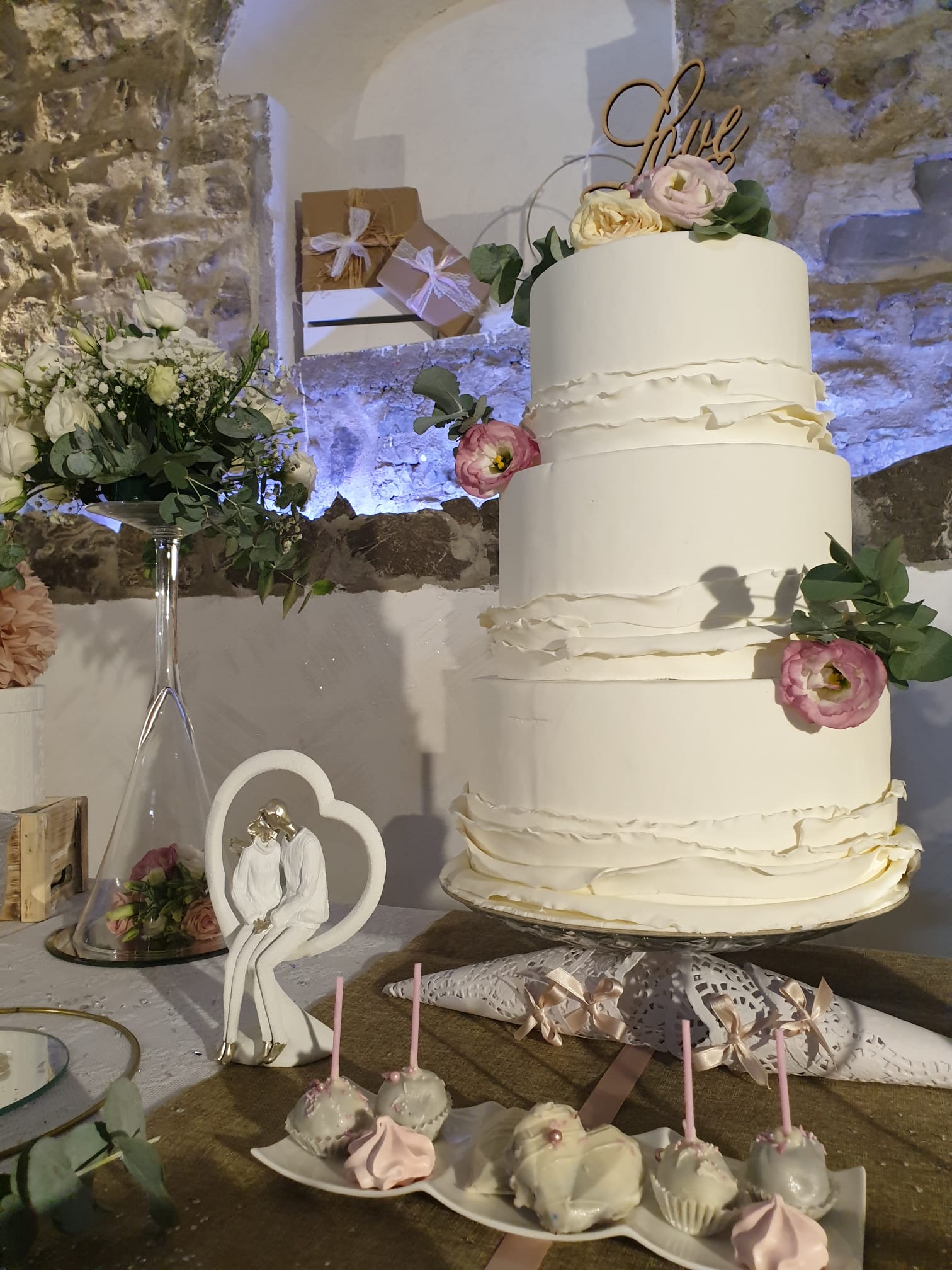 torta nuziale bianca è appoggiata su un tavolo