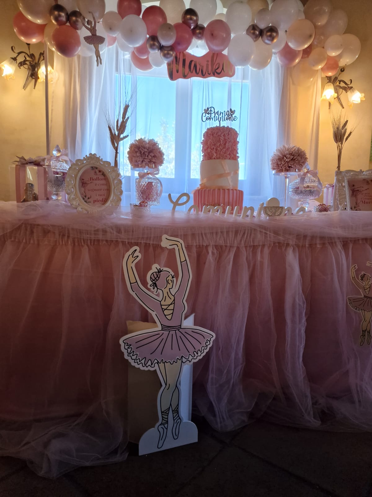 tavolo con una decorazione a forma di ballerina e palloncini sopra