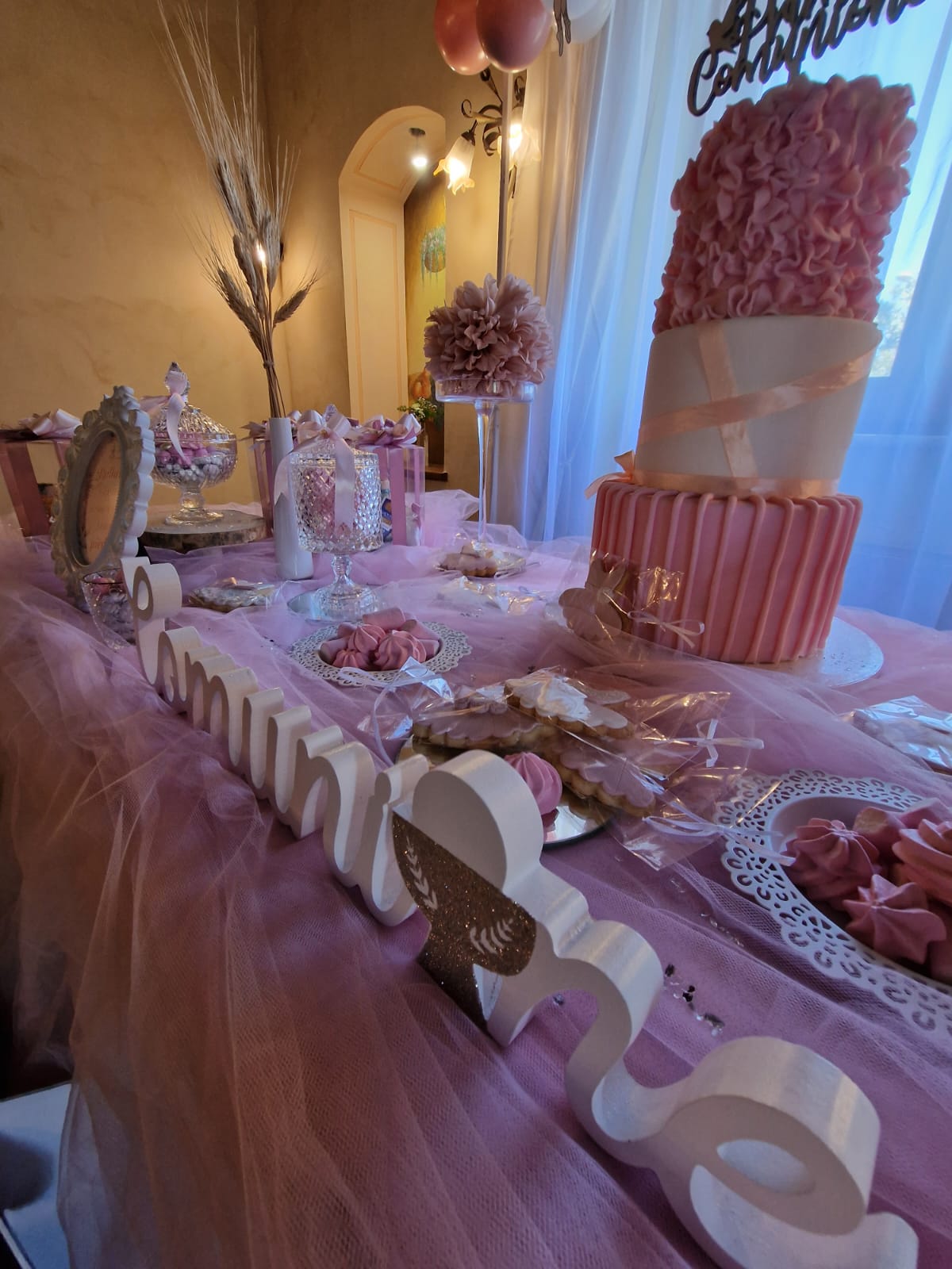 tavolo con una tovaglia rosa e una torta sopra