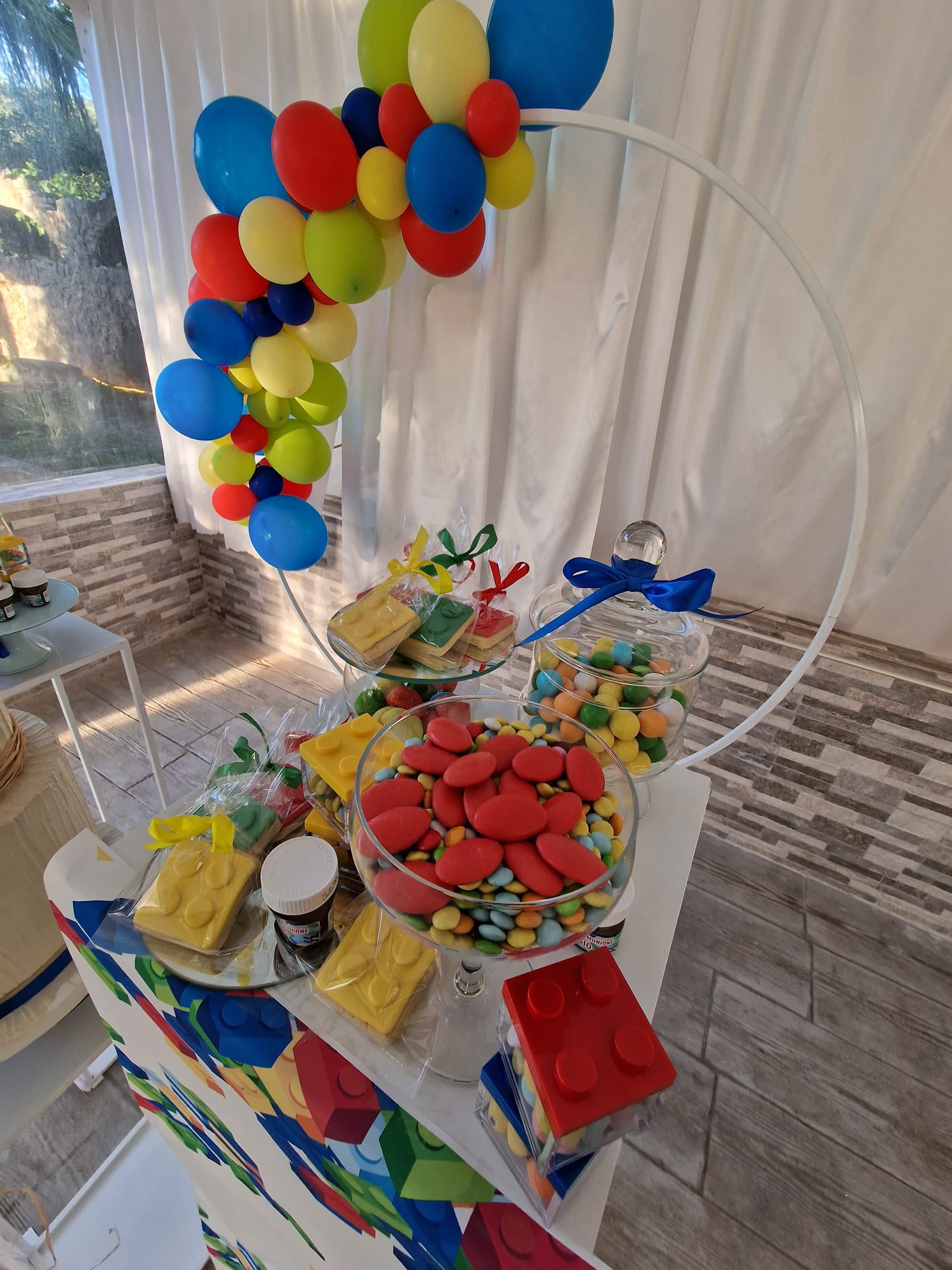 tavolo decorato con palloncini, caramelle e mattoncini Lego sopra