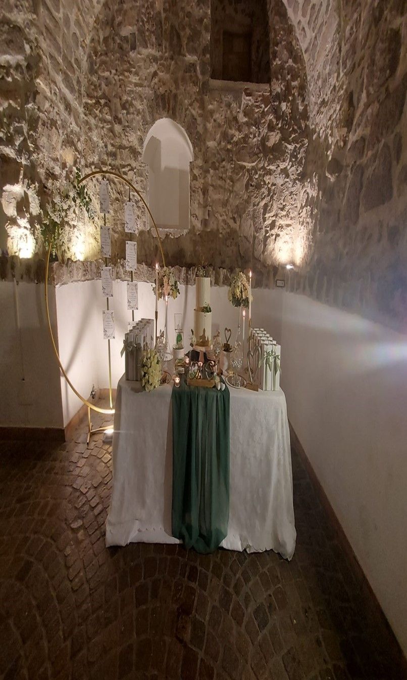 tavolo con candele e fiori in una stanza di pietra