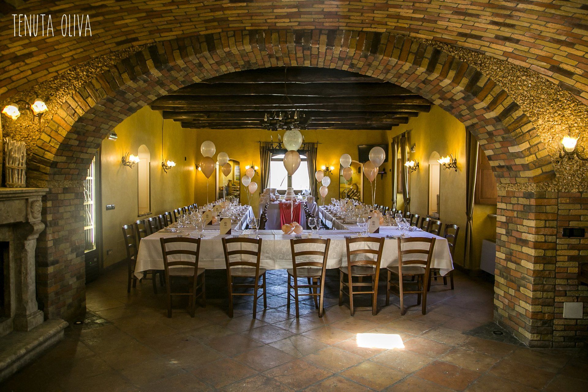 lungo tavolo e delle sedie in una stanza con un arco in mattoni