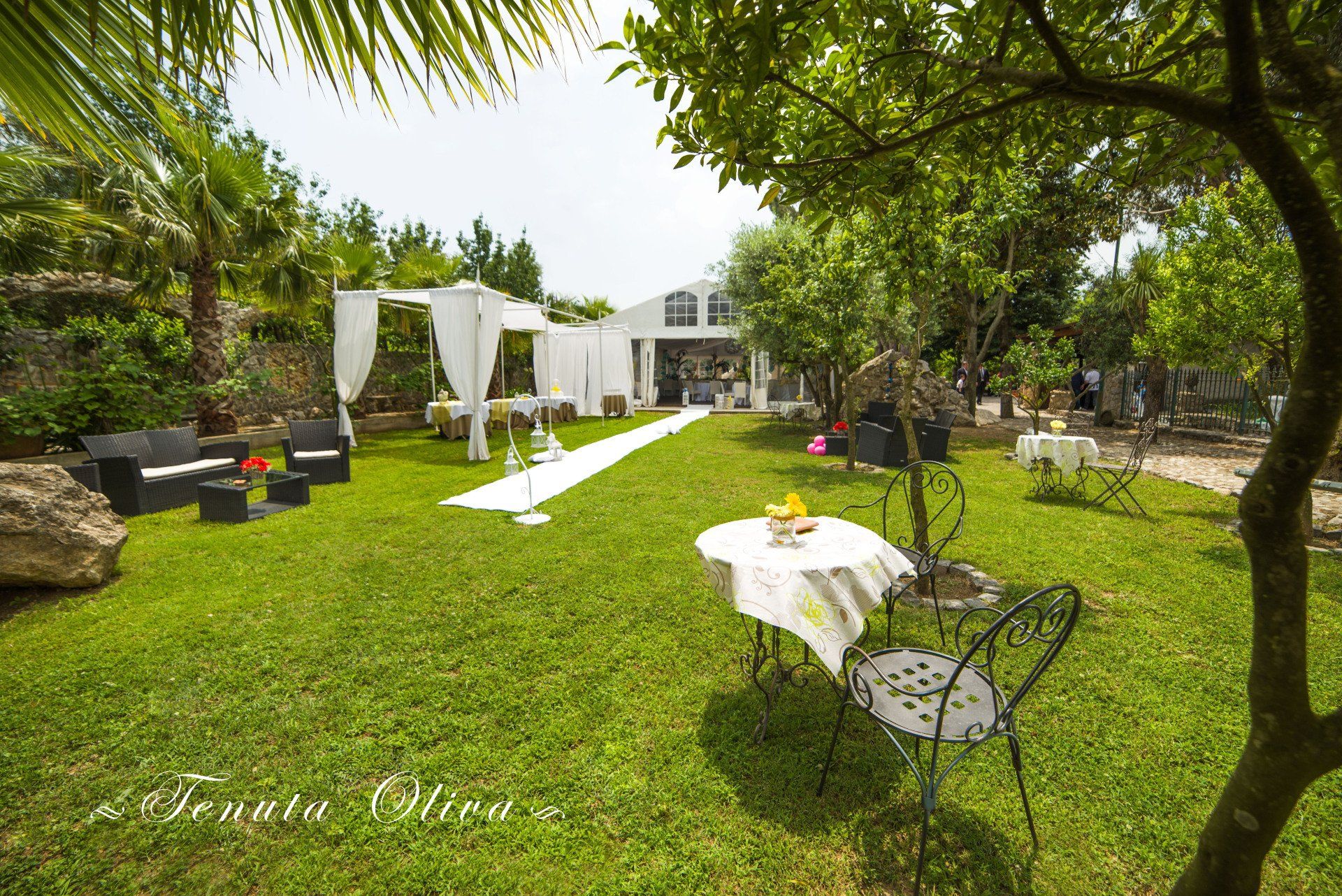 giardino allestito con tavoli e sedie per un battesimo