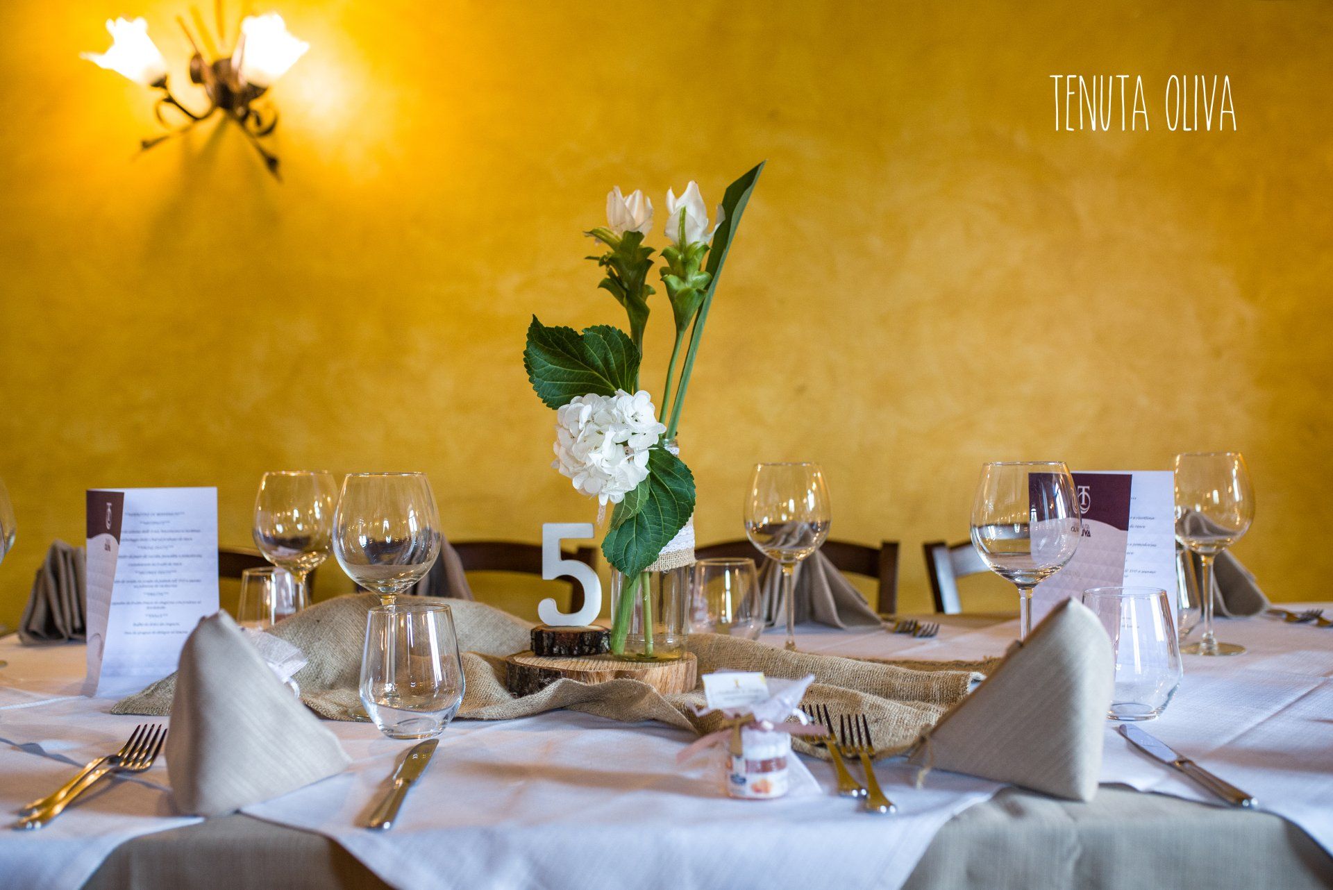 tavolo con un vaso di fiori e un segnaposto numerato