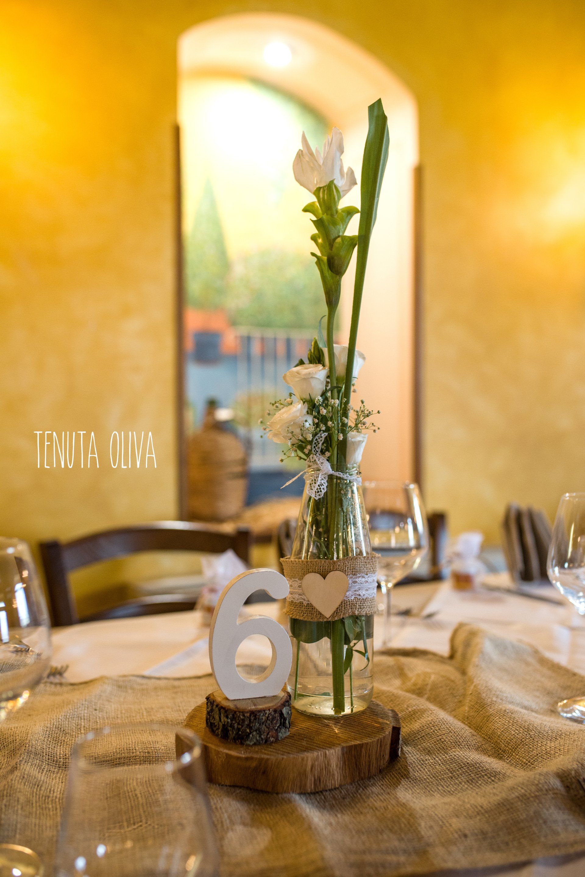 tavolo con un vaso di fiori e un segnaposto