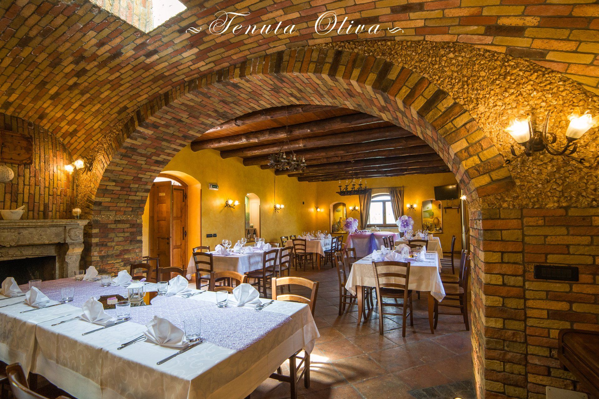 interno ristorante Tenuta Olivia con tavoli e sedie e un muro di mattoni