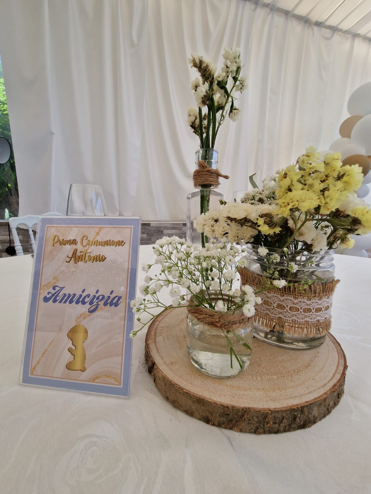 tavolo con un cartello e vasi di fiori sopra