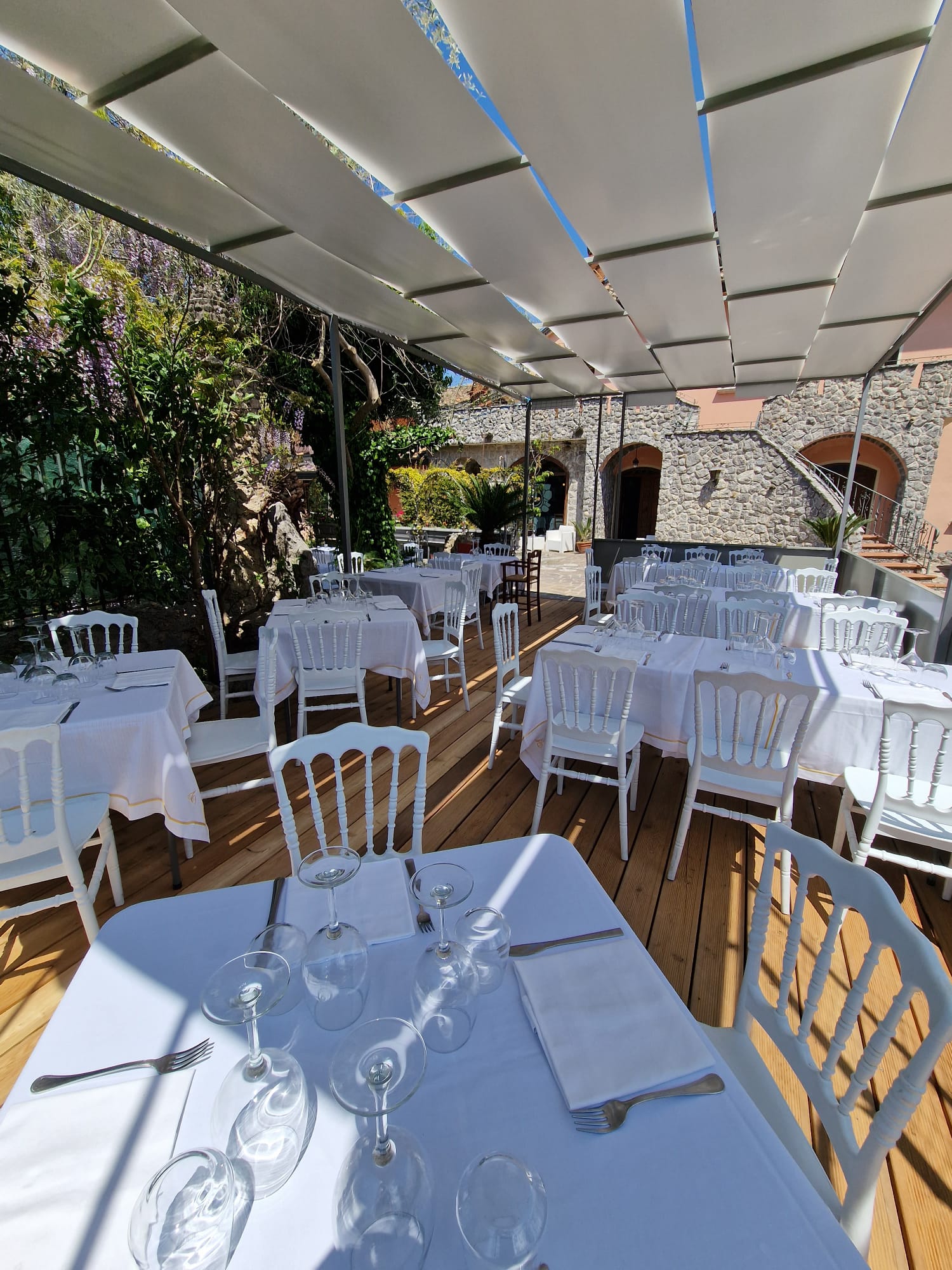 ristorante con tavoli e sedie sistemati sotto una tettoia