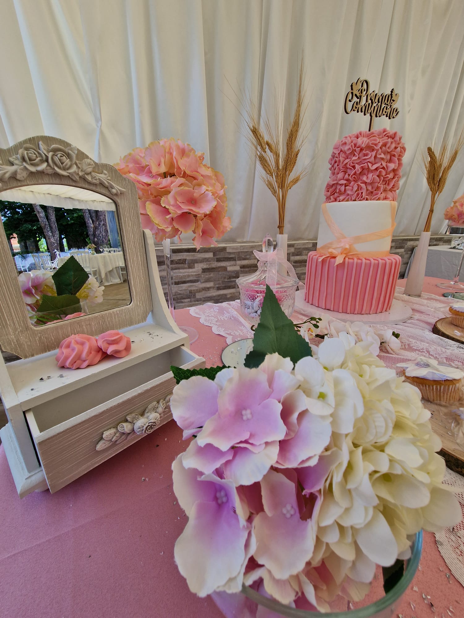 tavolo con dei fiori, uno specchio e una torta sopra