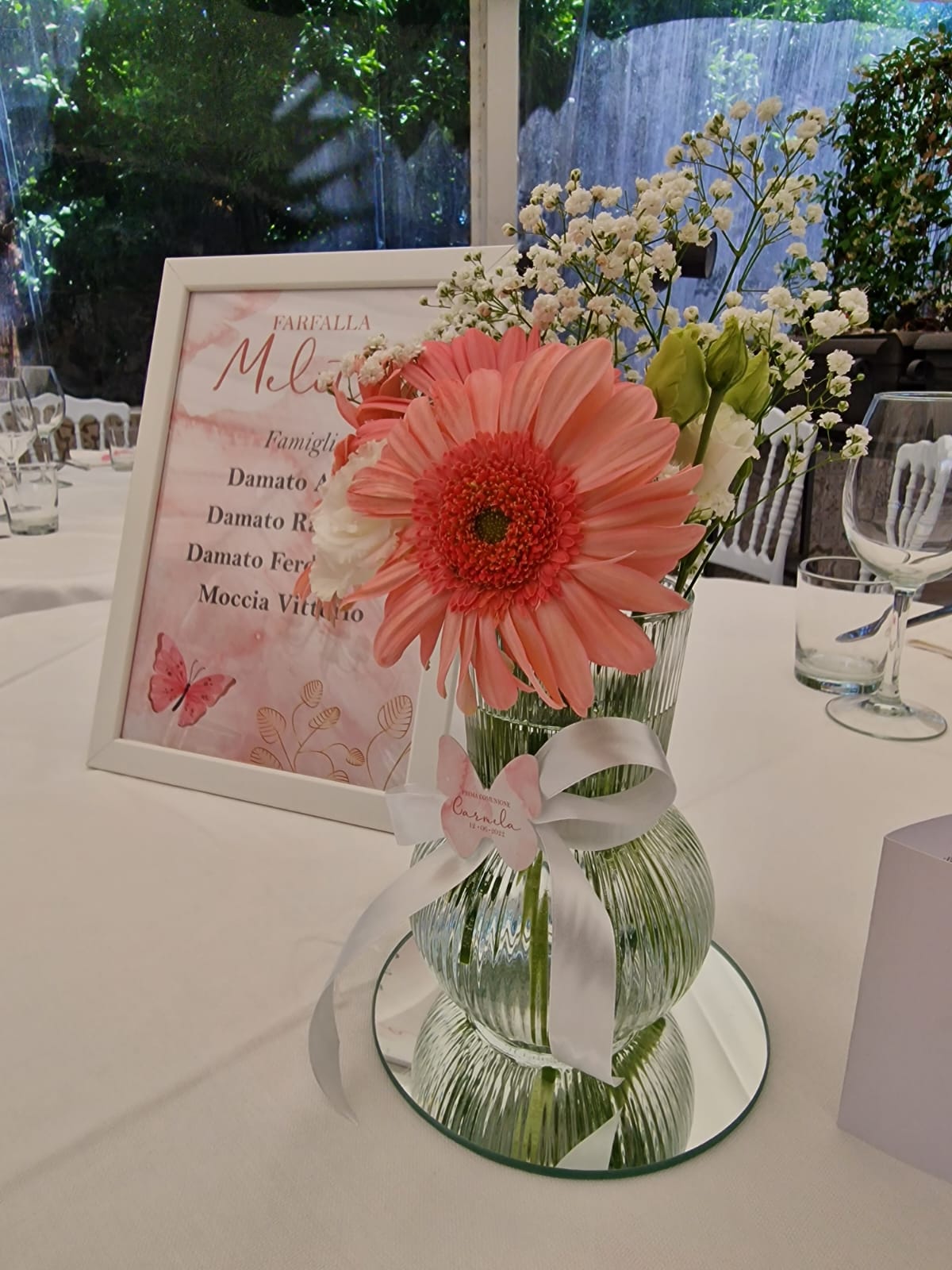 tavolo con un vaso di fiori e un menù al centro