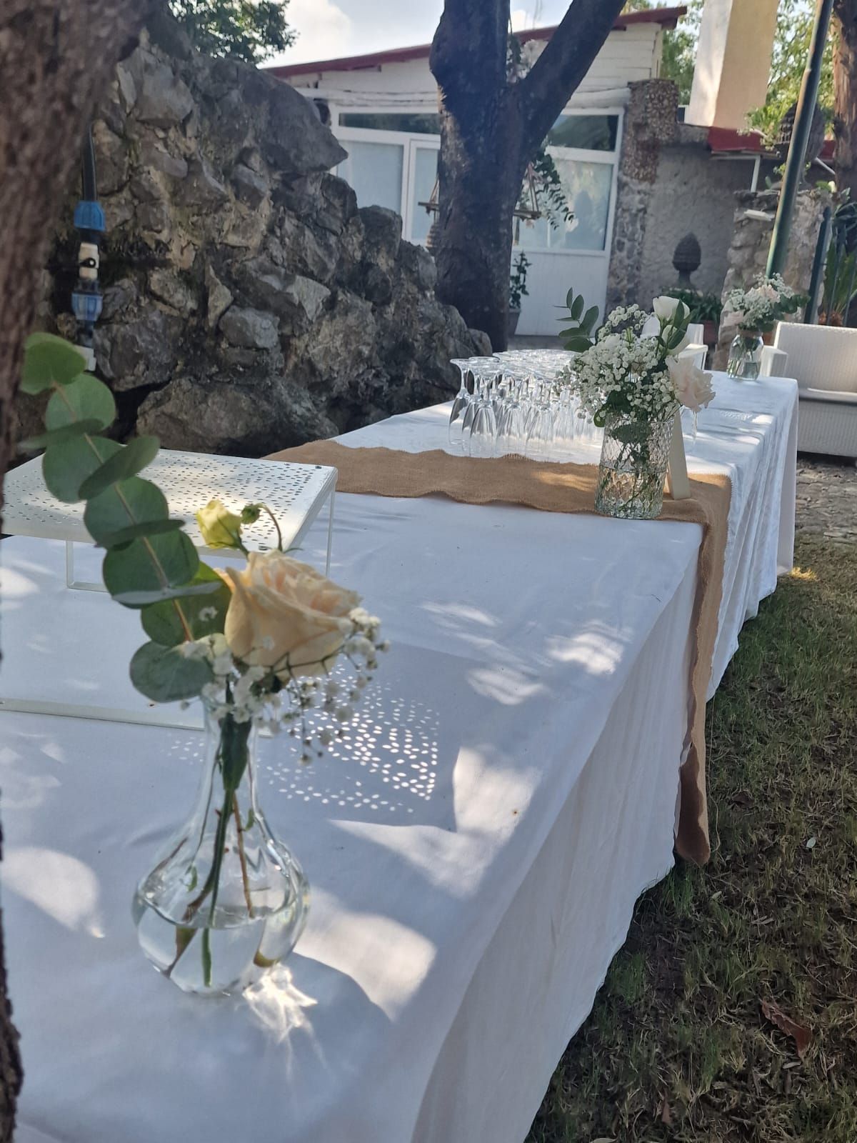 lungo tavolo con sopra un vaso di fiori.