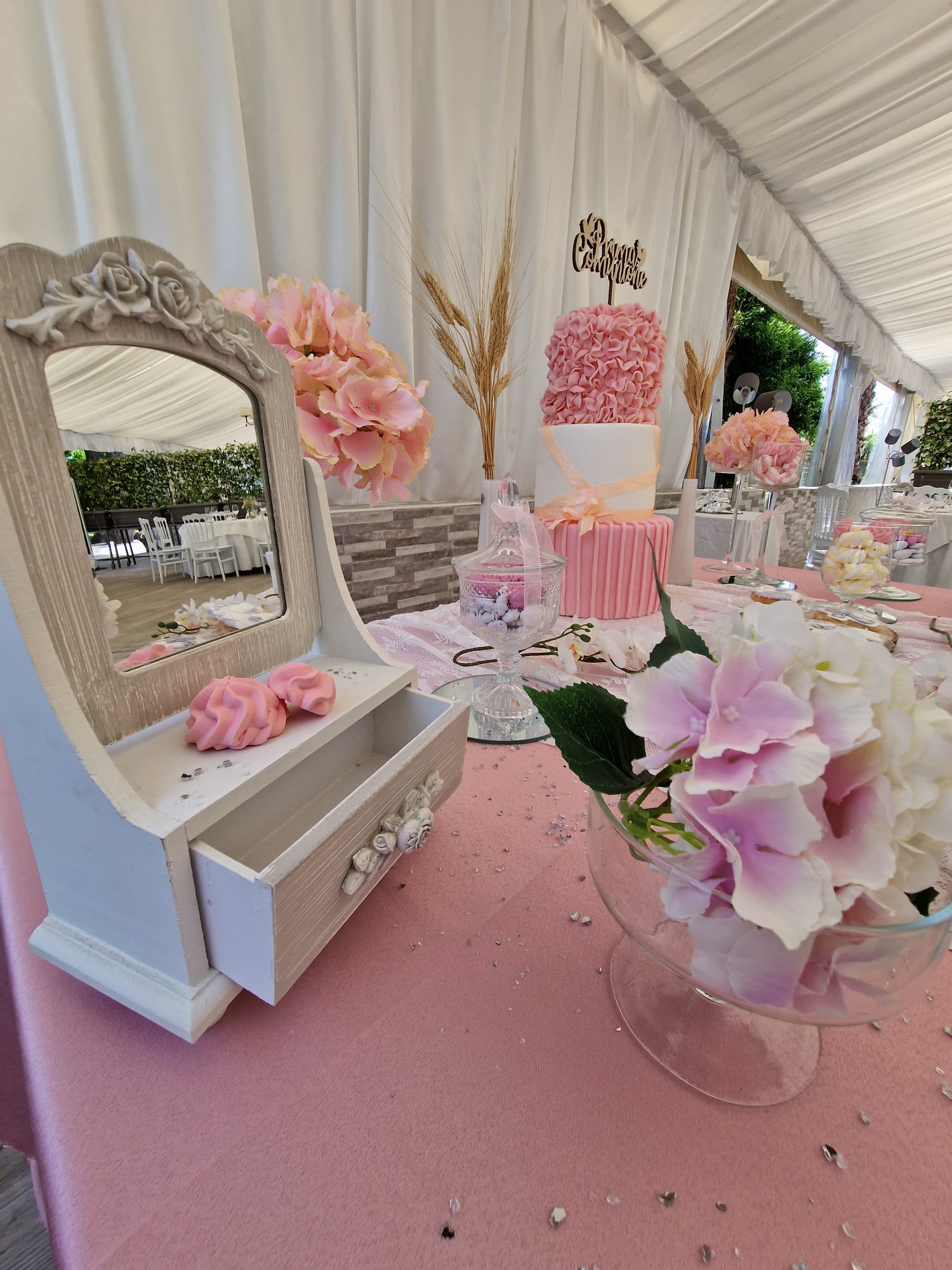 Un tavolo con uno specchio e dei fiori sopra.