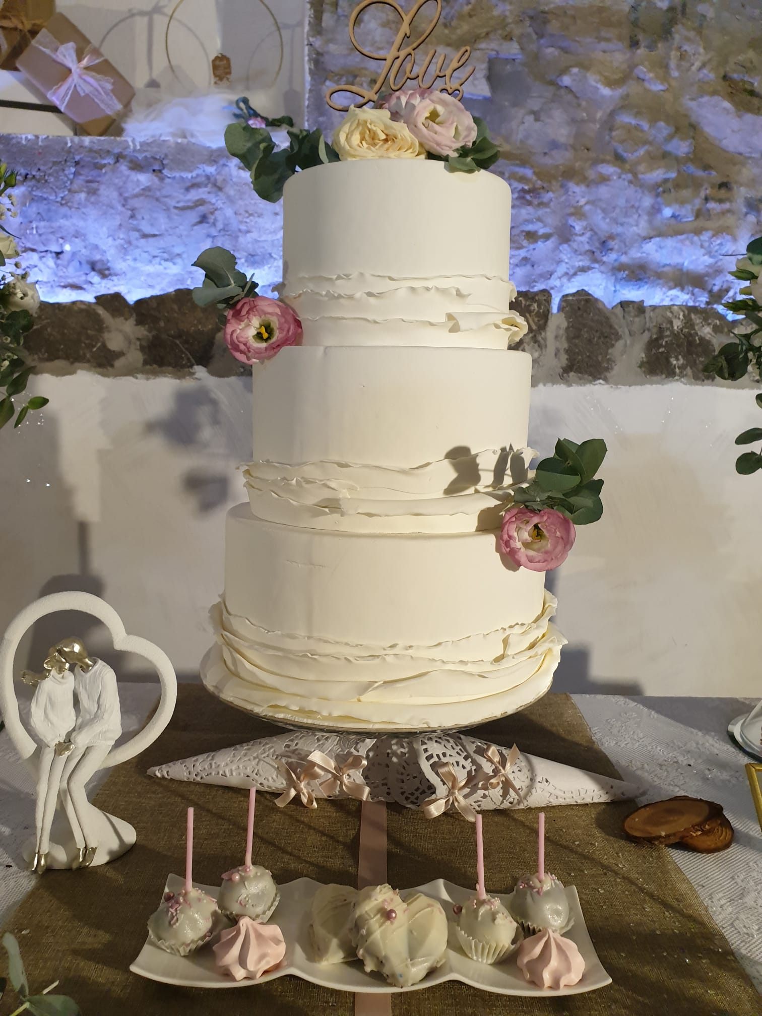 Una torta nuziale bianca è appoggiata su un tavolo.