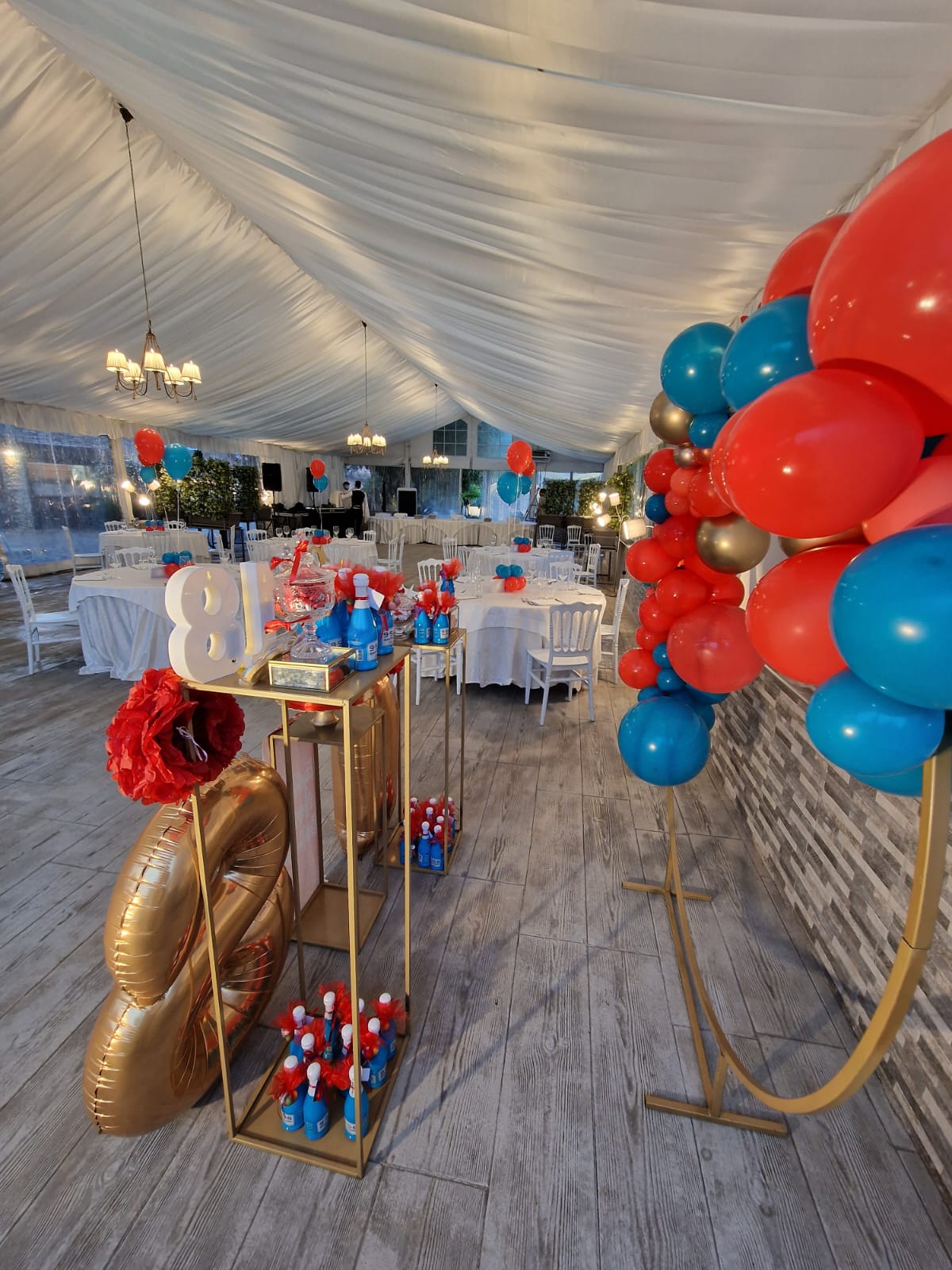 stanza con tavoli e sedie decorata con palloncini di diversi colori