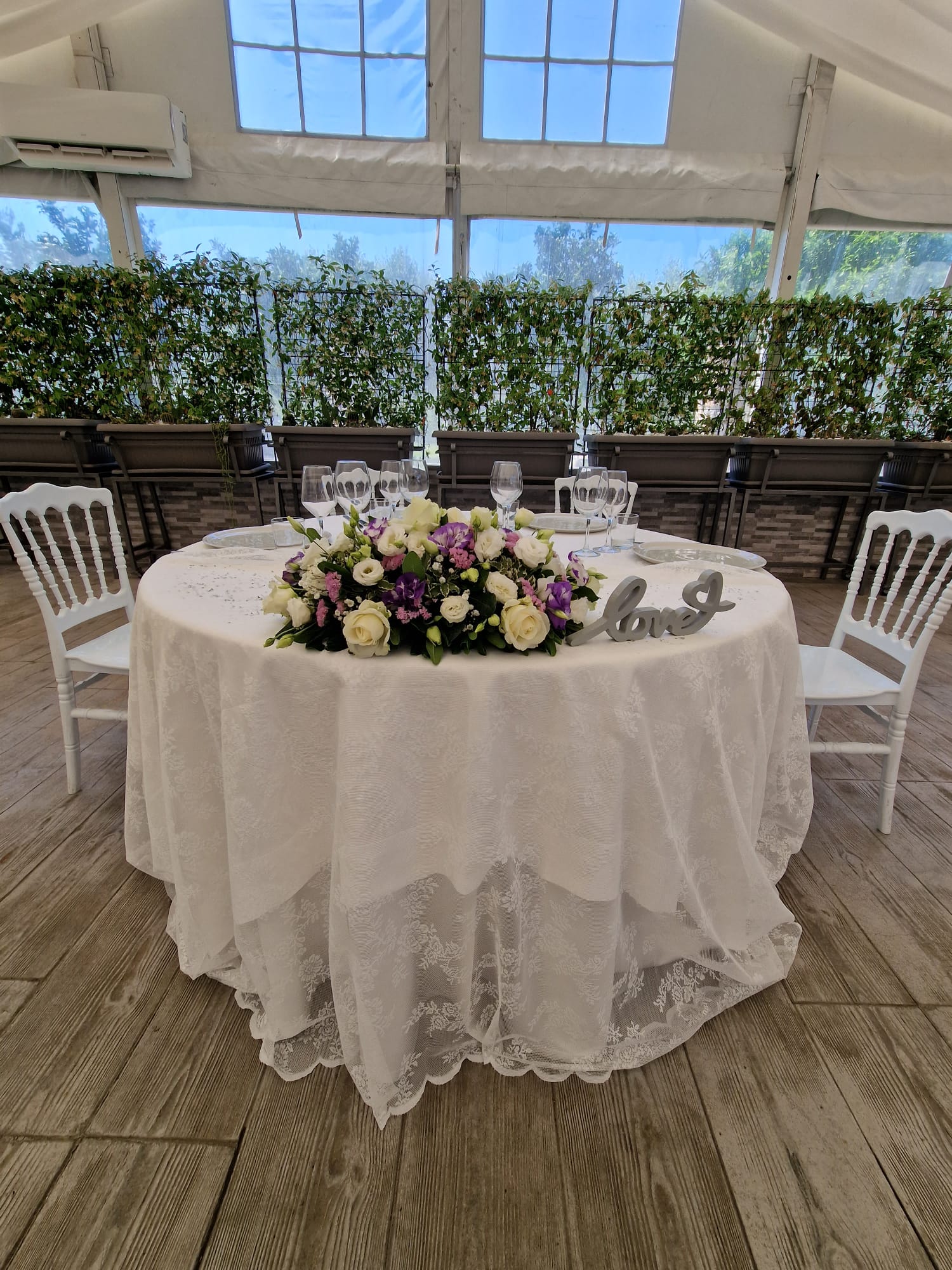 tavolo con una tovaglia bianca e dei fiori sopra