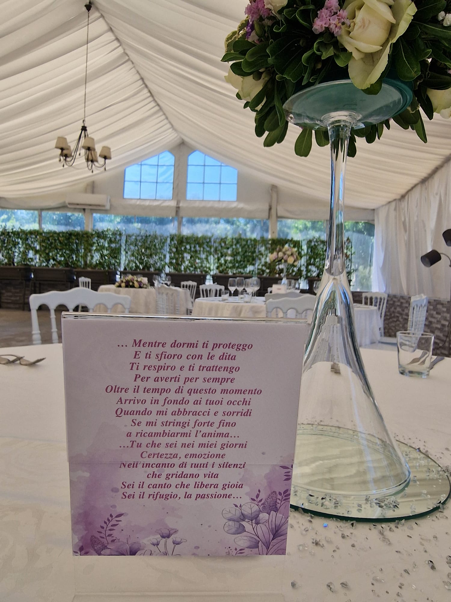 tavolo con un vaso di fiori e un segnaposto