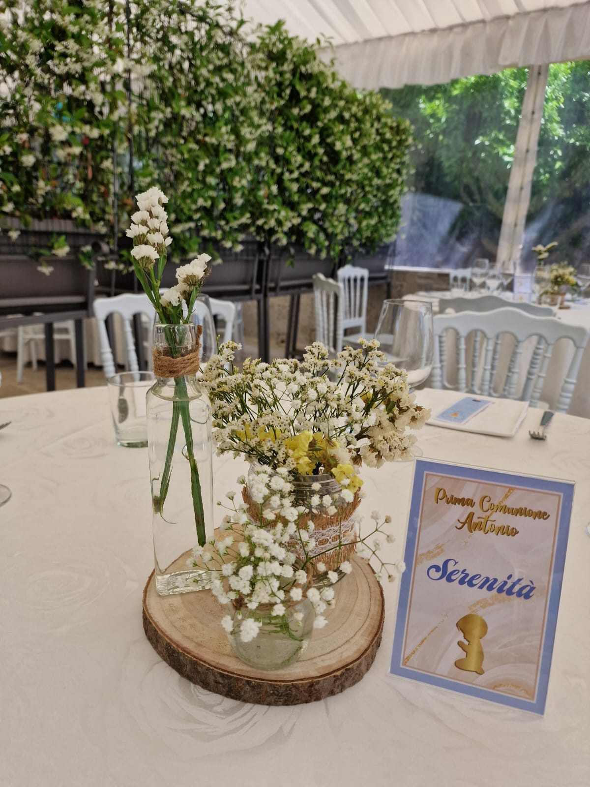 tavolo con dei fiori e un cartello con una scritta