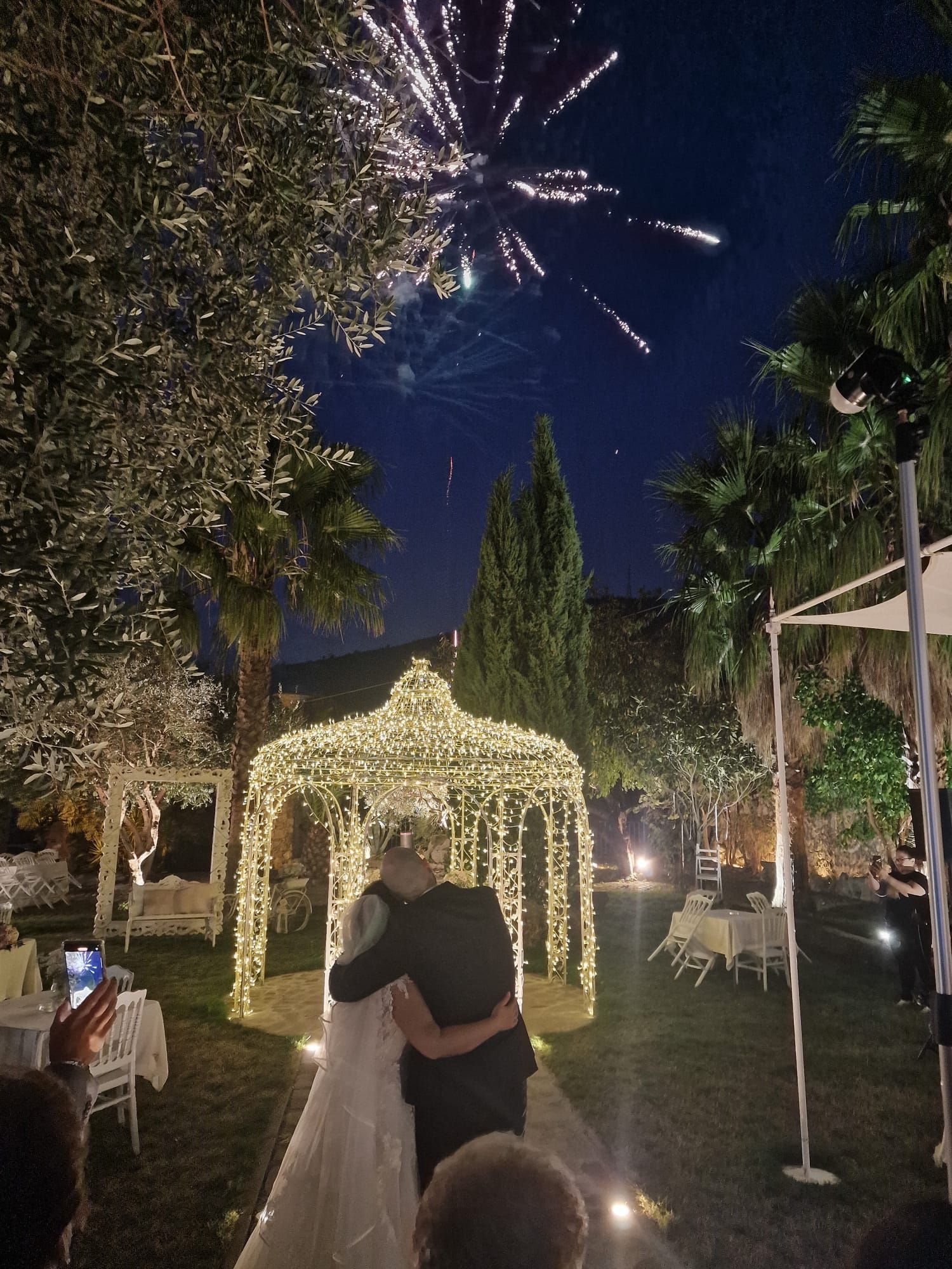 una sposa e uno sposo si baciano sotto un gazebo