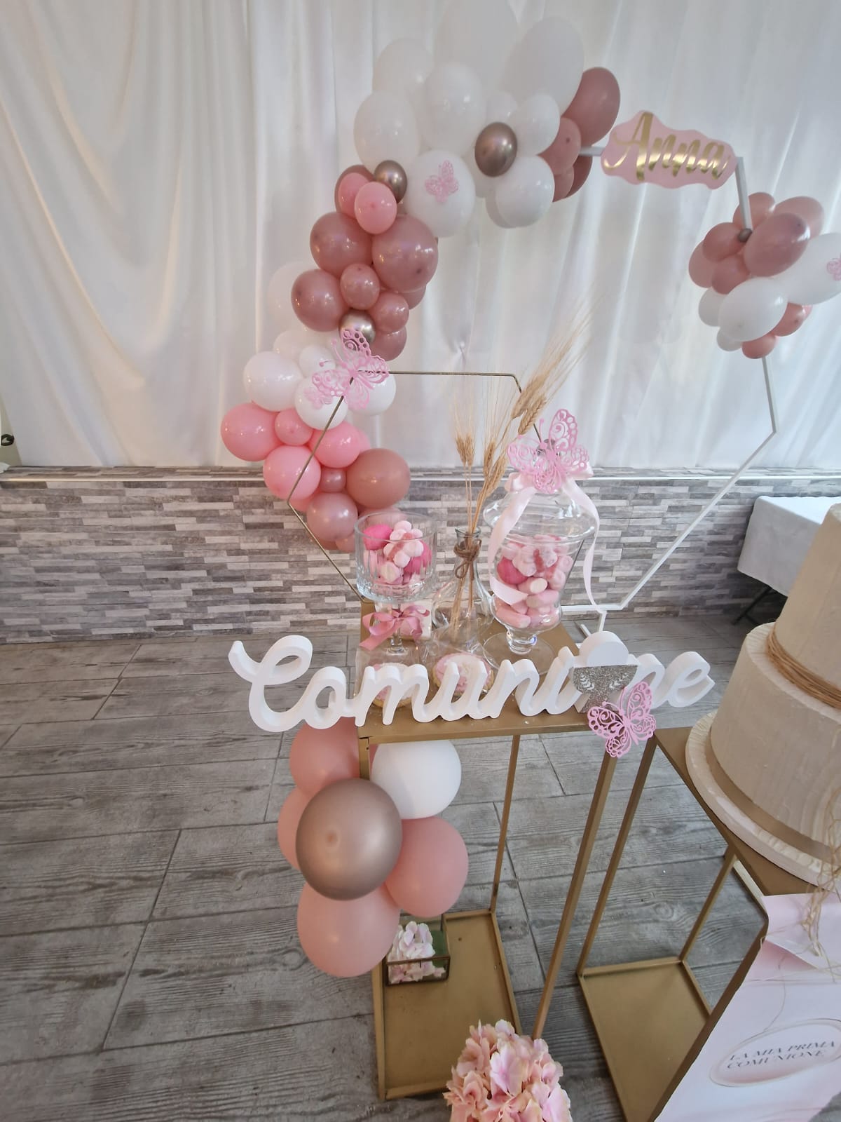 tavolo con dei palloncini e un cartello con la scritta comunione