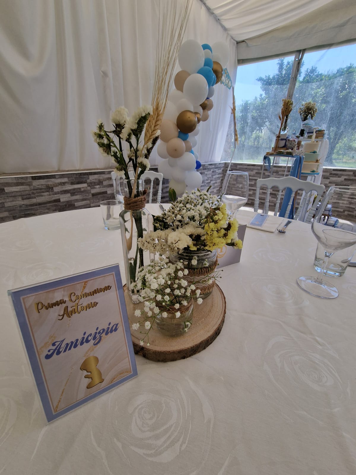 tavolo con un vaso di fiori e palloncini sopra