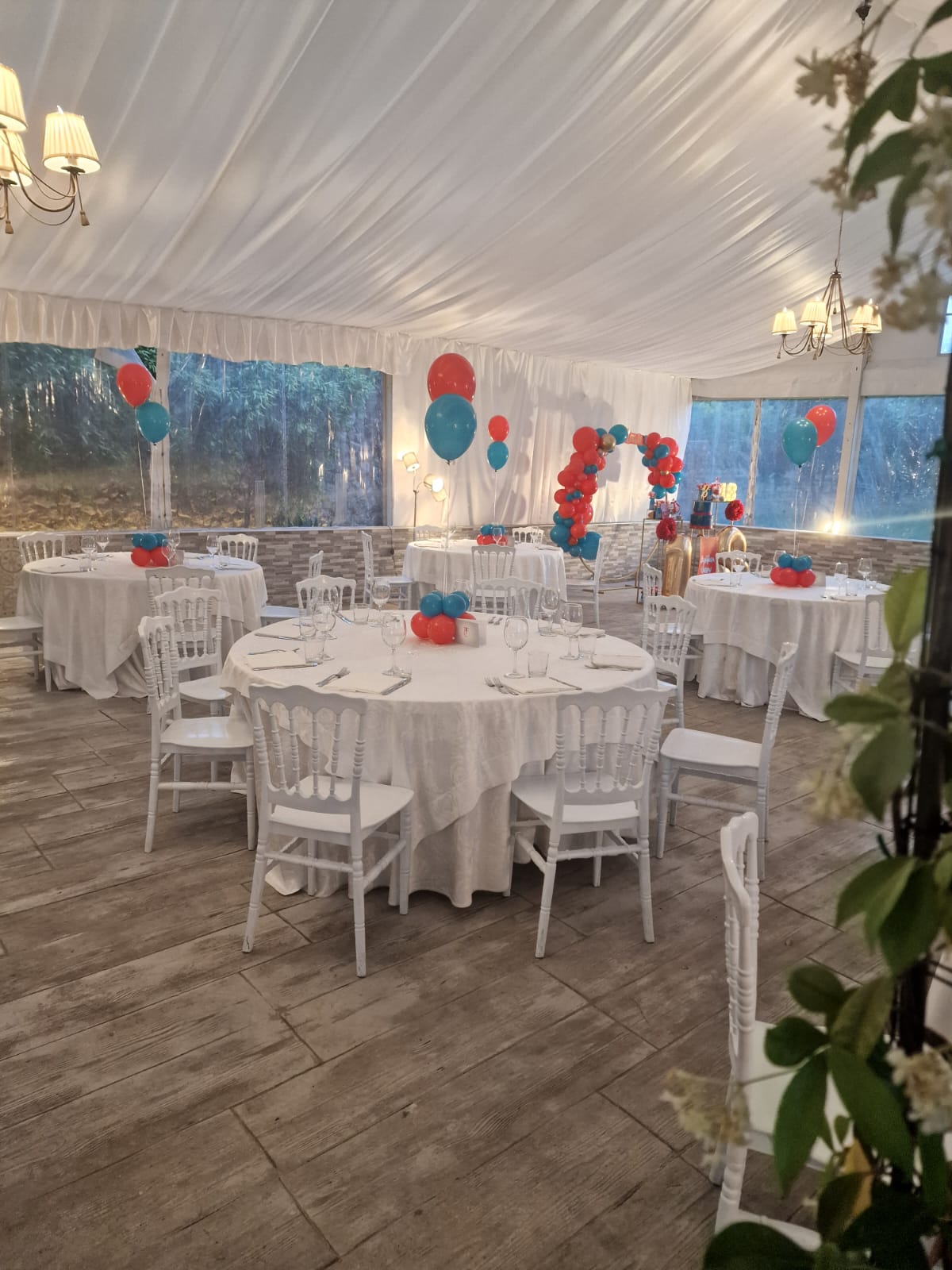 una grande stanza piena di tavoli, sedie e palloncini