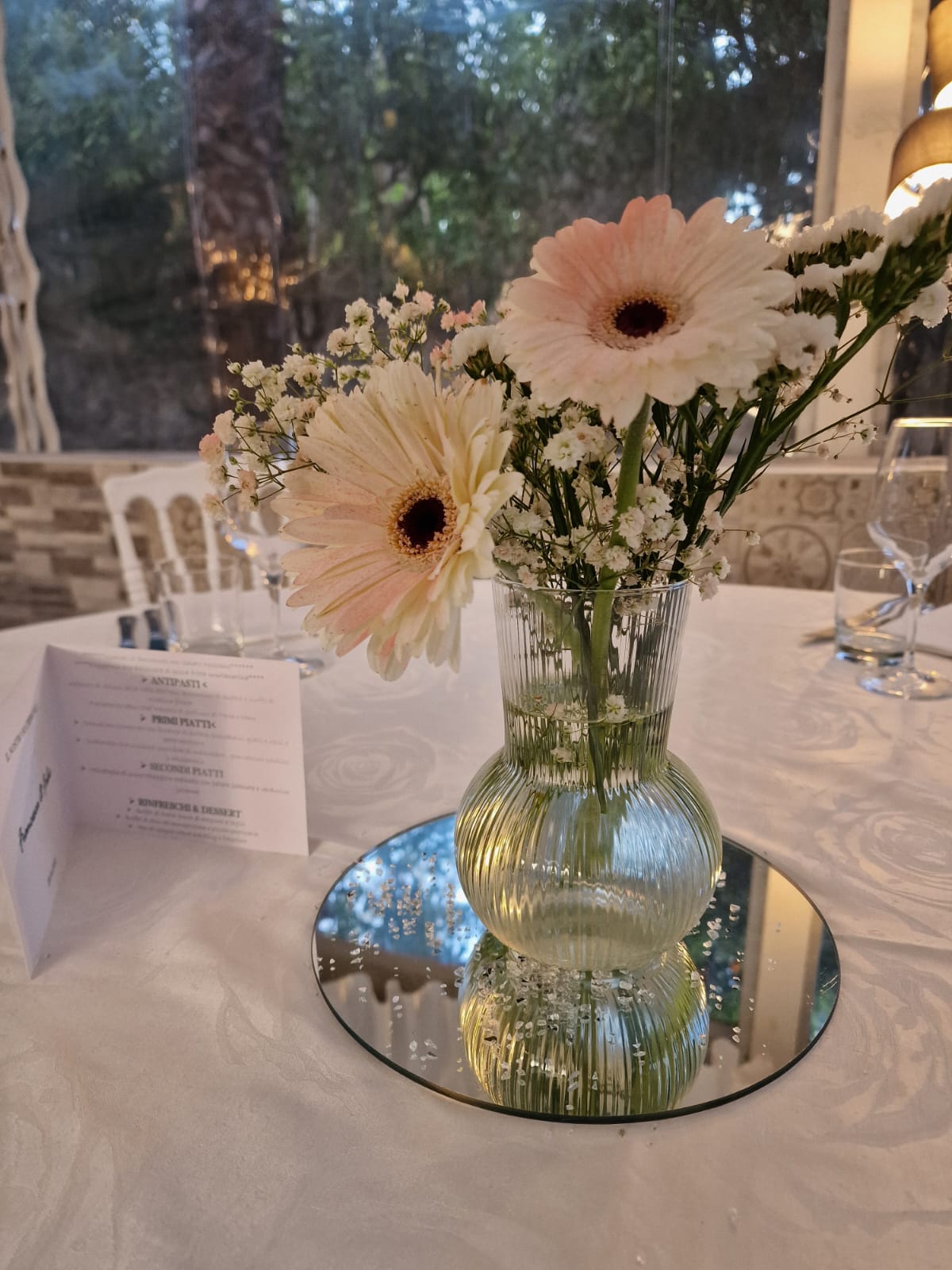 Un vaso pieno di fiori è appoggiato su un tavolo.