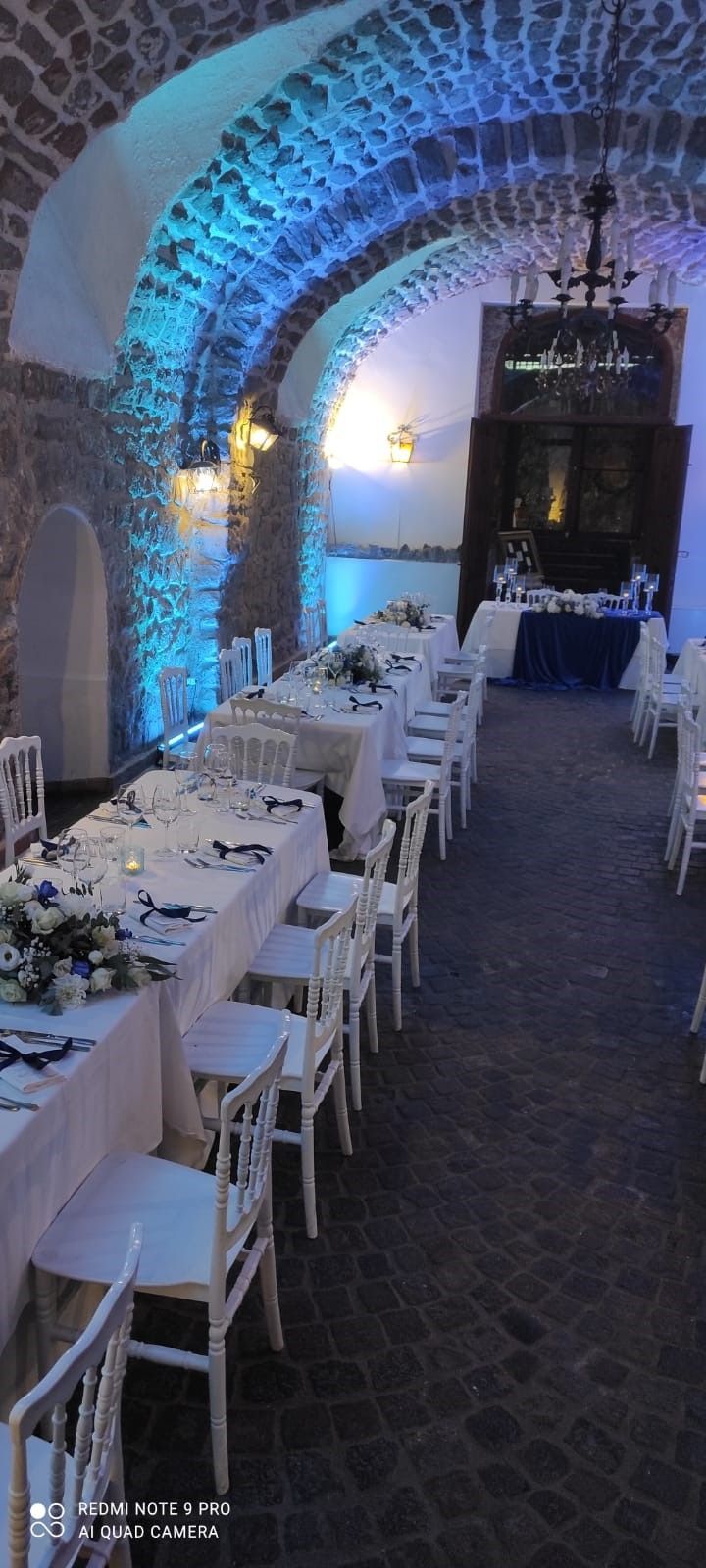 lungo tavolo e delle sedie in una stanza con luci blu