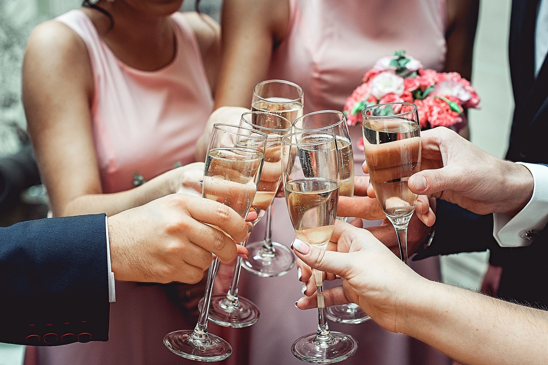 People hold in hands glasses with white wine. wedding party. friends toasting with a champagne.