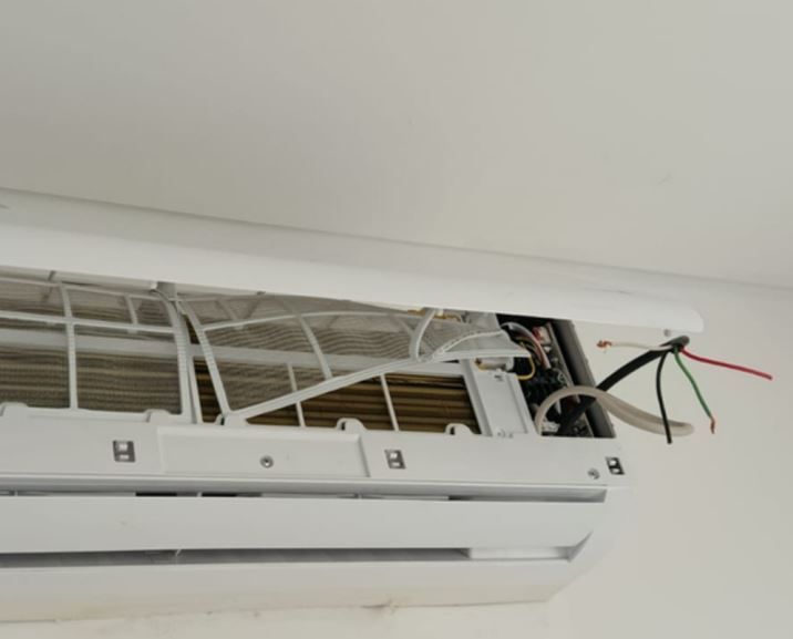 Grúa de construcción encima de un edificio de gran altura en construcción contra un cielo azul.