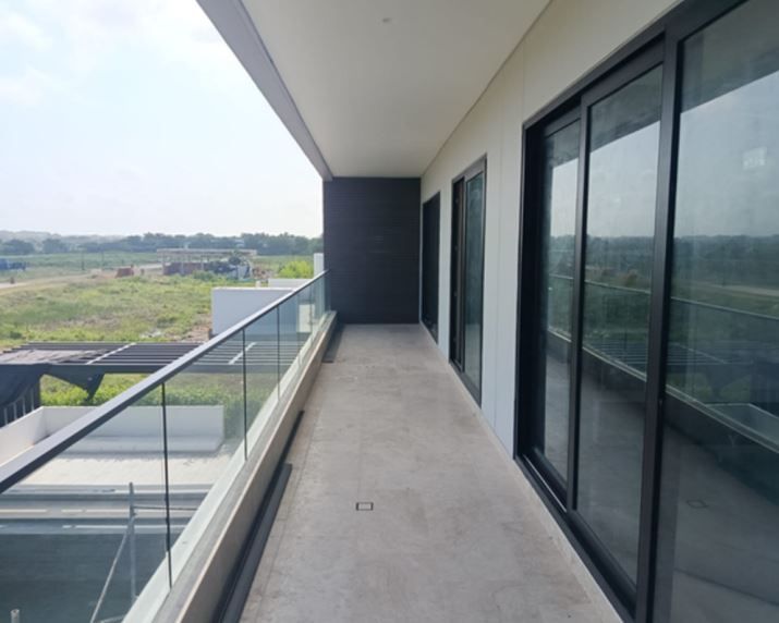 Sitio de construcción con paletas de ladrillos rojos, una grúa y un edificio en construcción.