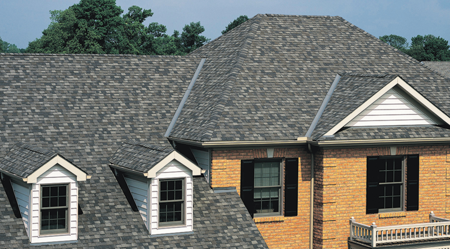 A brick house with a gray roof and white trim