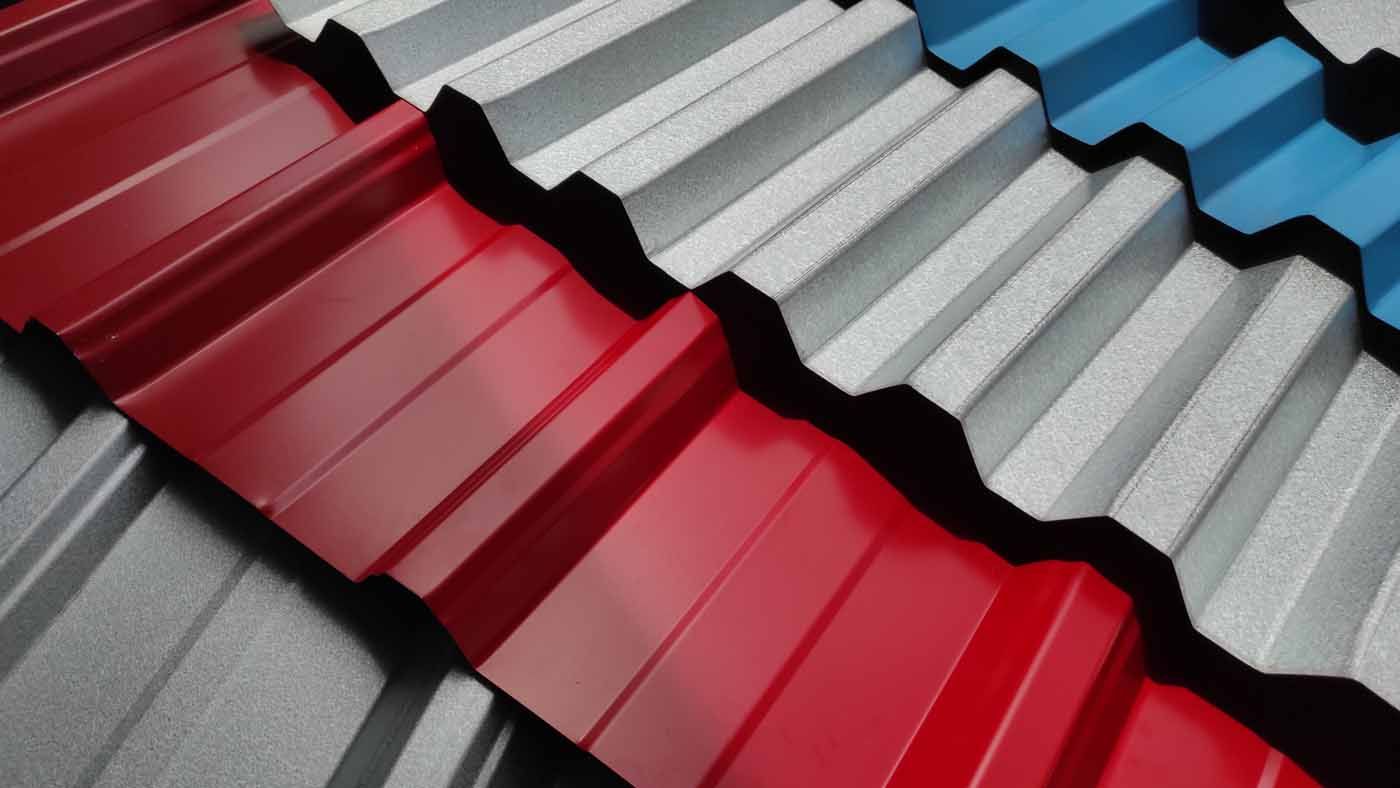 A bunch of different colored metal roofing sheets are stacked on top of each other.