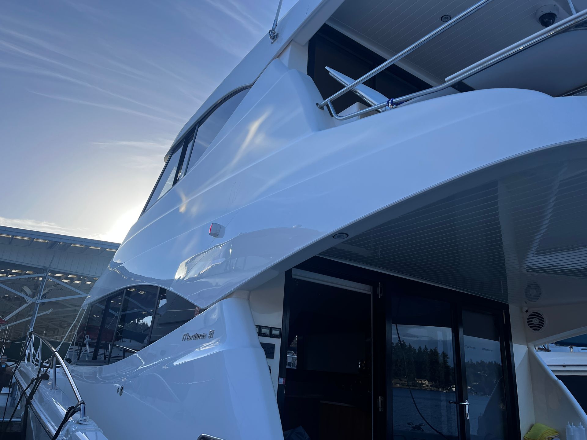 A large white yacht is docked in a marina.