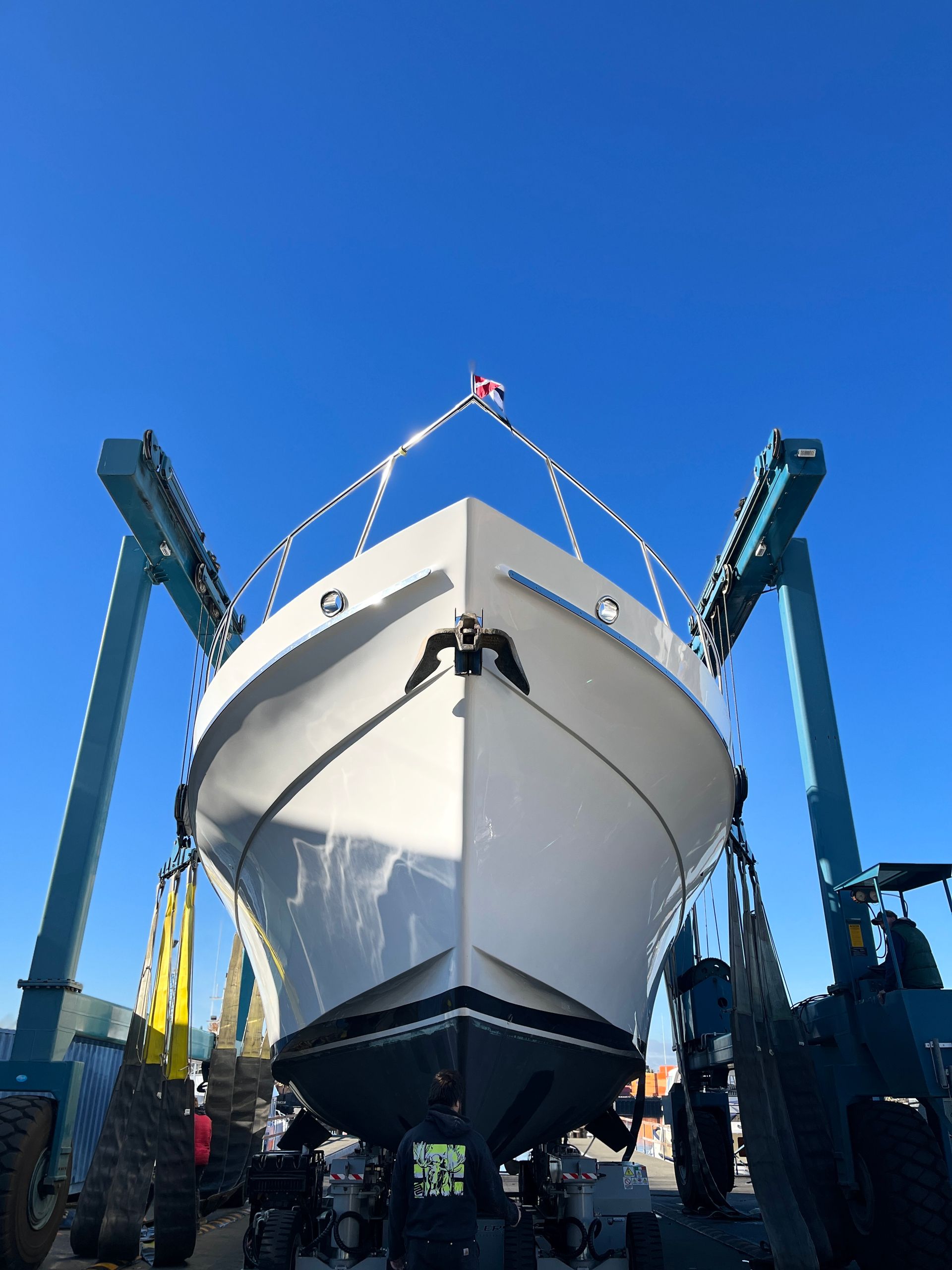 A large white boat is being lifted by a crane